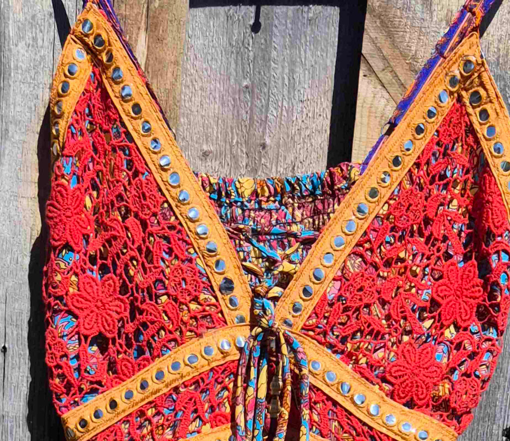 Detail van de bovenkant van een boho maxi jurk met paisley print in blauw en rood, met kant en verstelbare bandjes Ibiza stijl