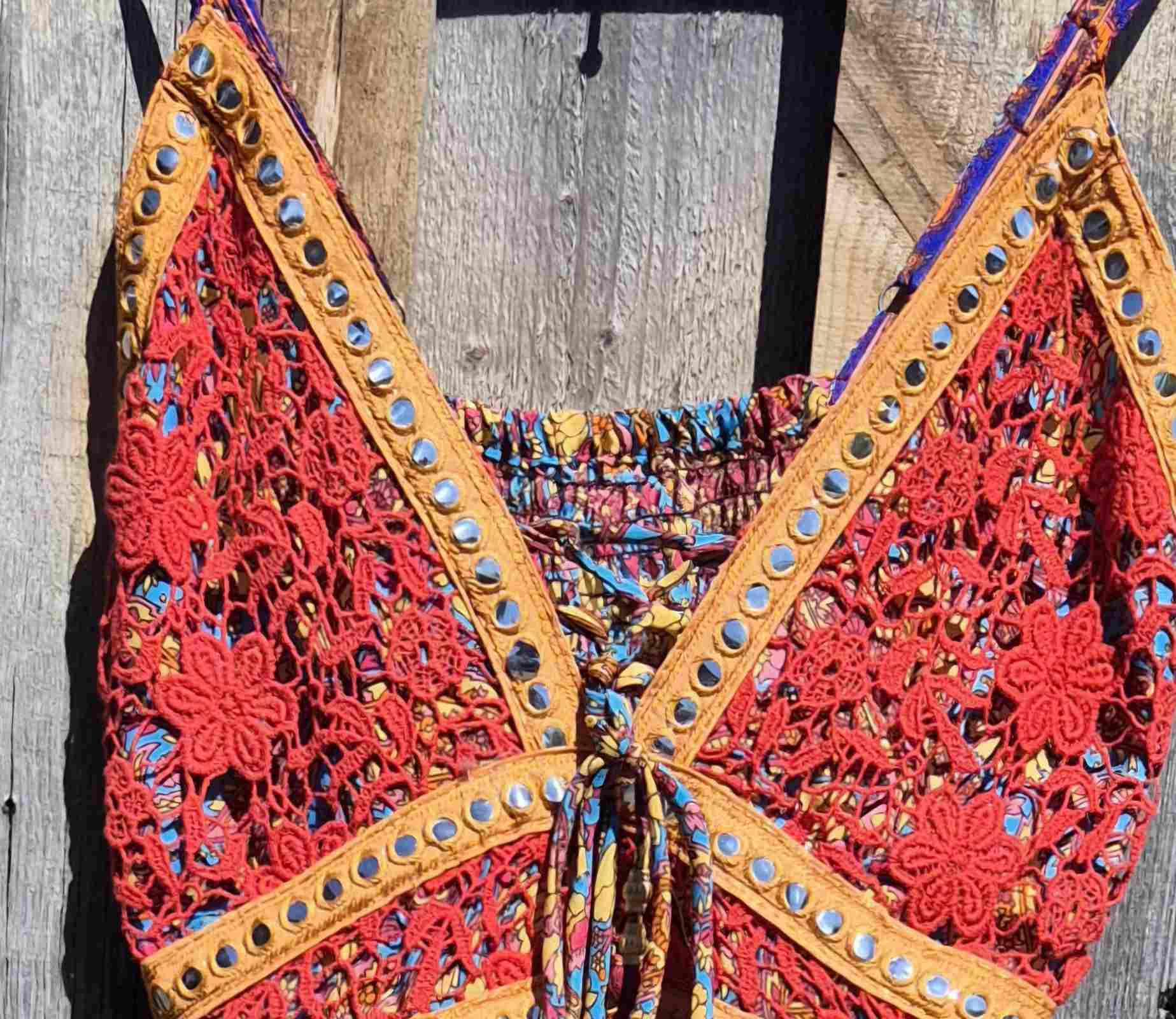 Detail van de bovenkant van een boho maxi jurk met paisley print in blauw en rood, met kant en verstelbare bandjes Ibiza stijl