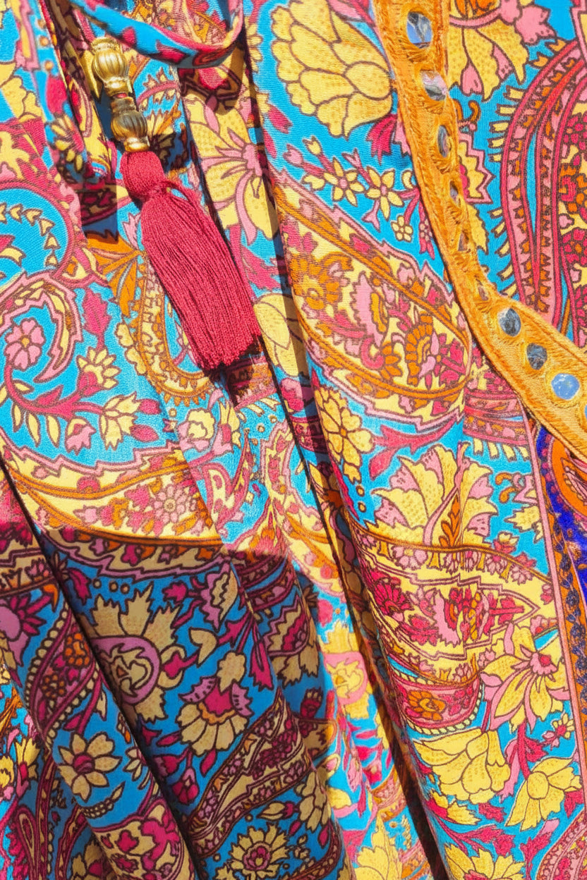 Detail van paisley print op boho maxi jurk in blauw en rood met Ibiza stijl en luchtige stof