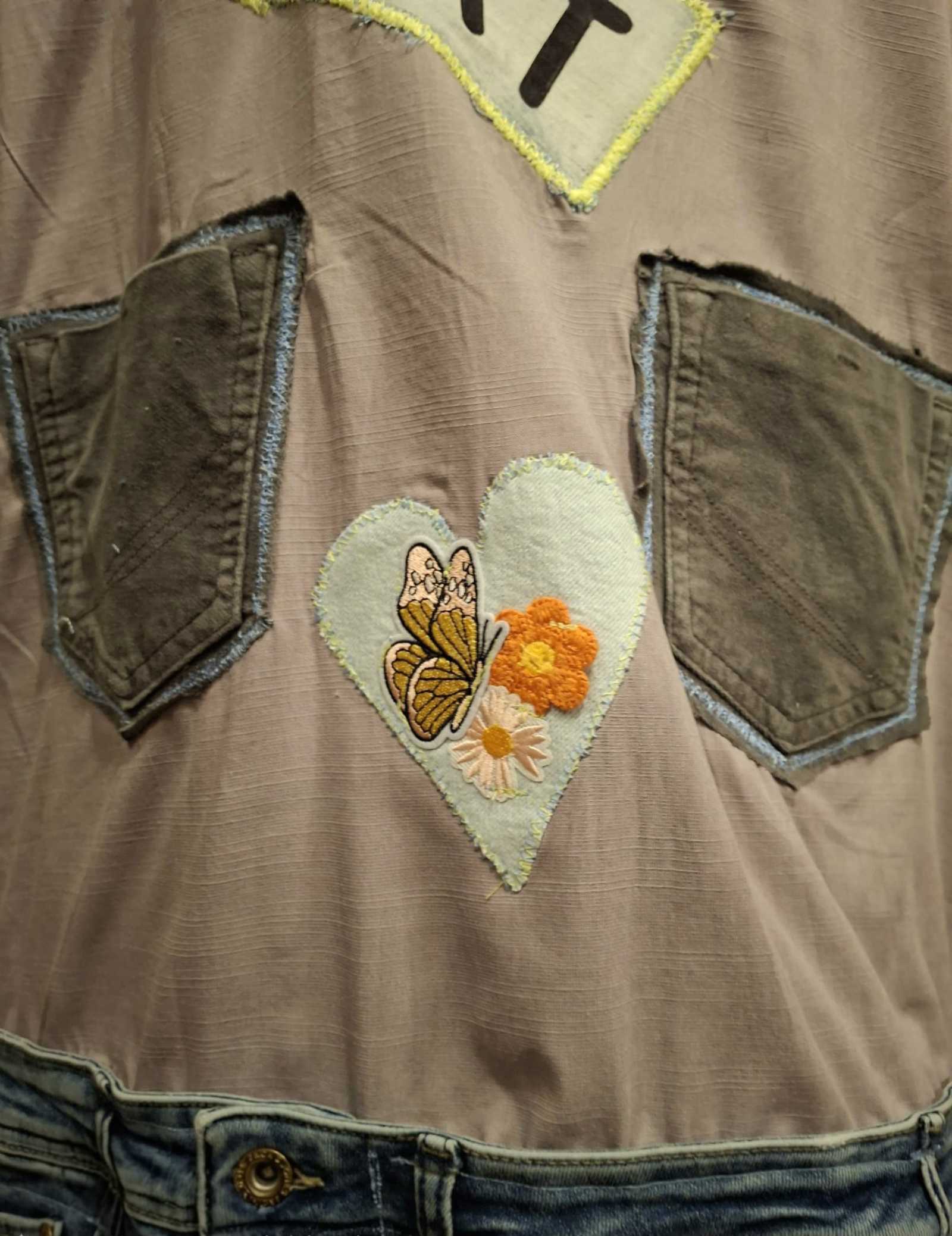 Detail van handgemaakt hartje met vlinder en bloemen op boho jasje