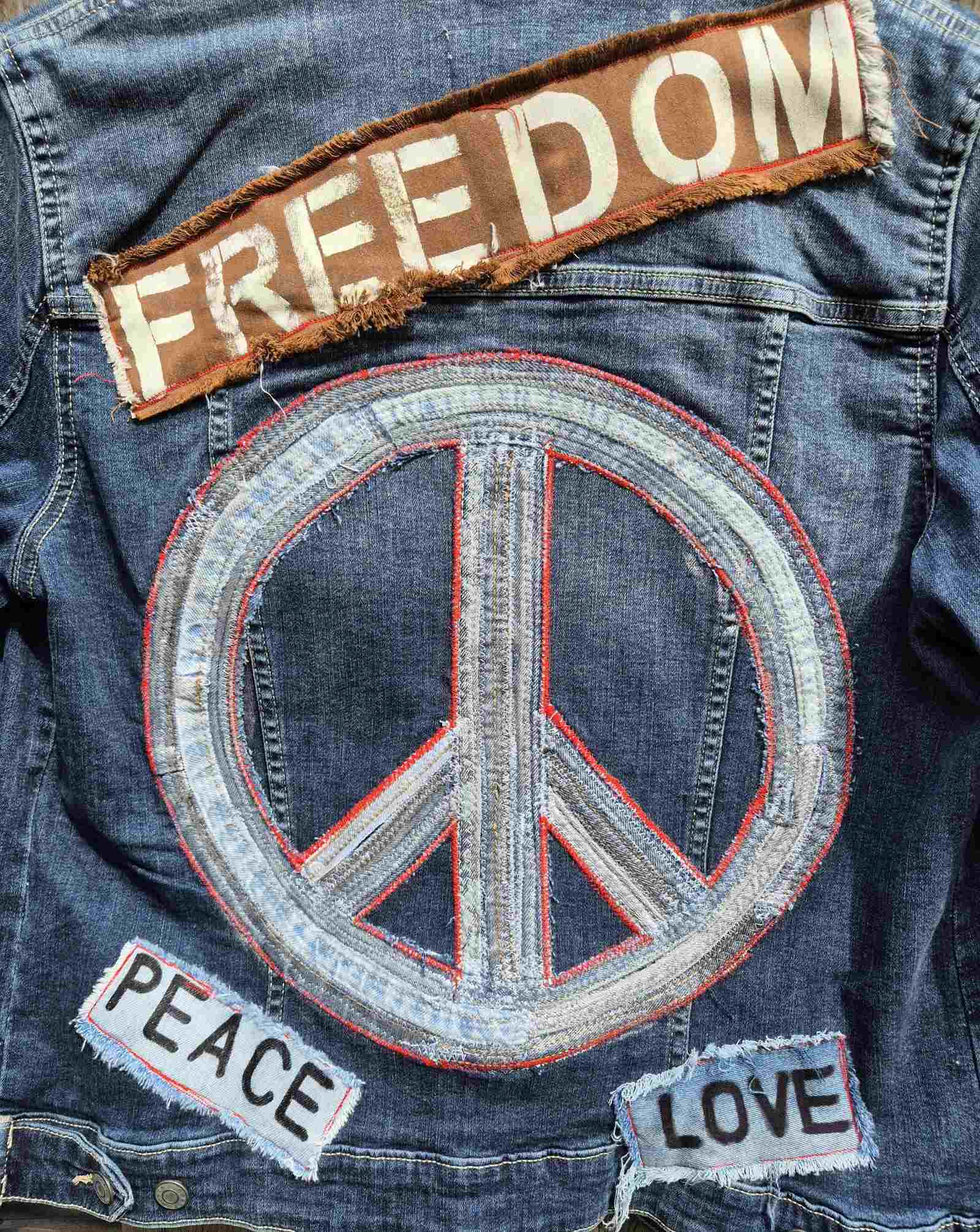 Detail van peace symbool op handgemaakt upcycled denim jasje