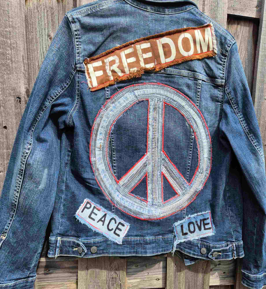 Detail van peace symbool op handgemaakt upcycled denim jasje