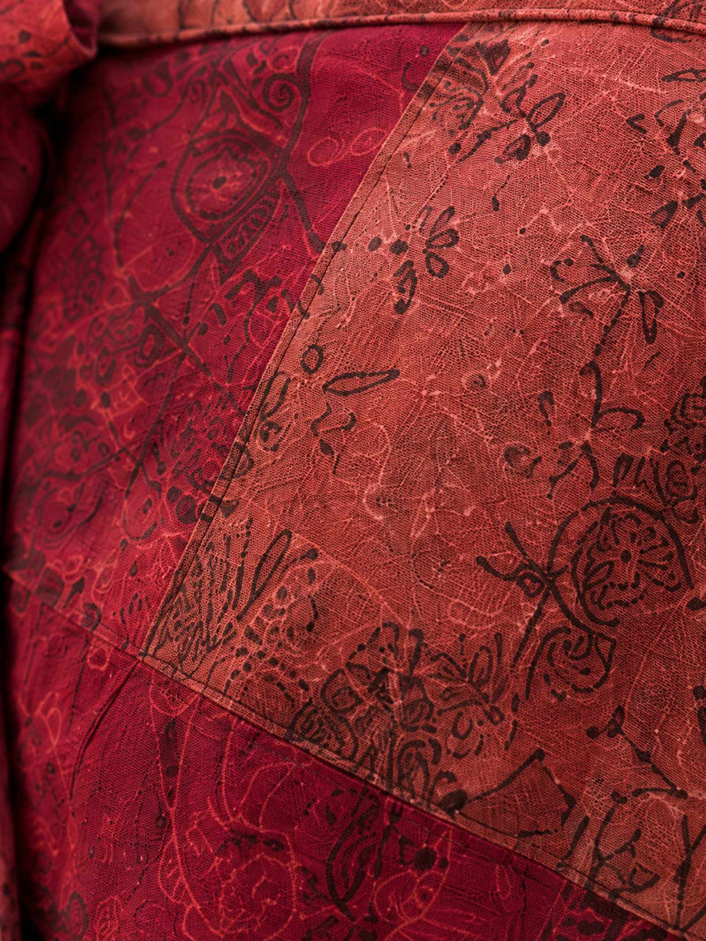 Close-up van de stevige 100% katoenen structuur van de rode patchwork wrap rok.