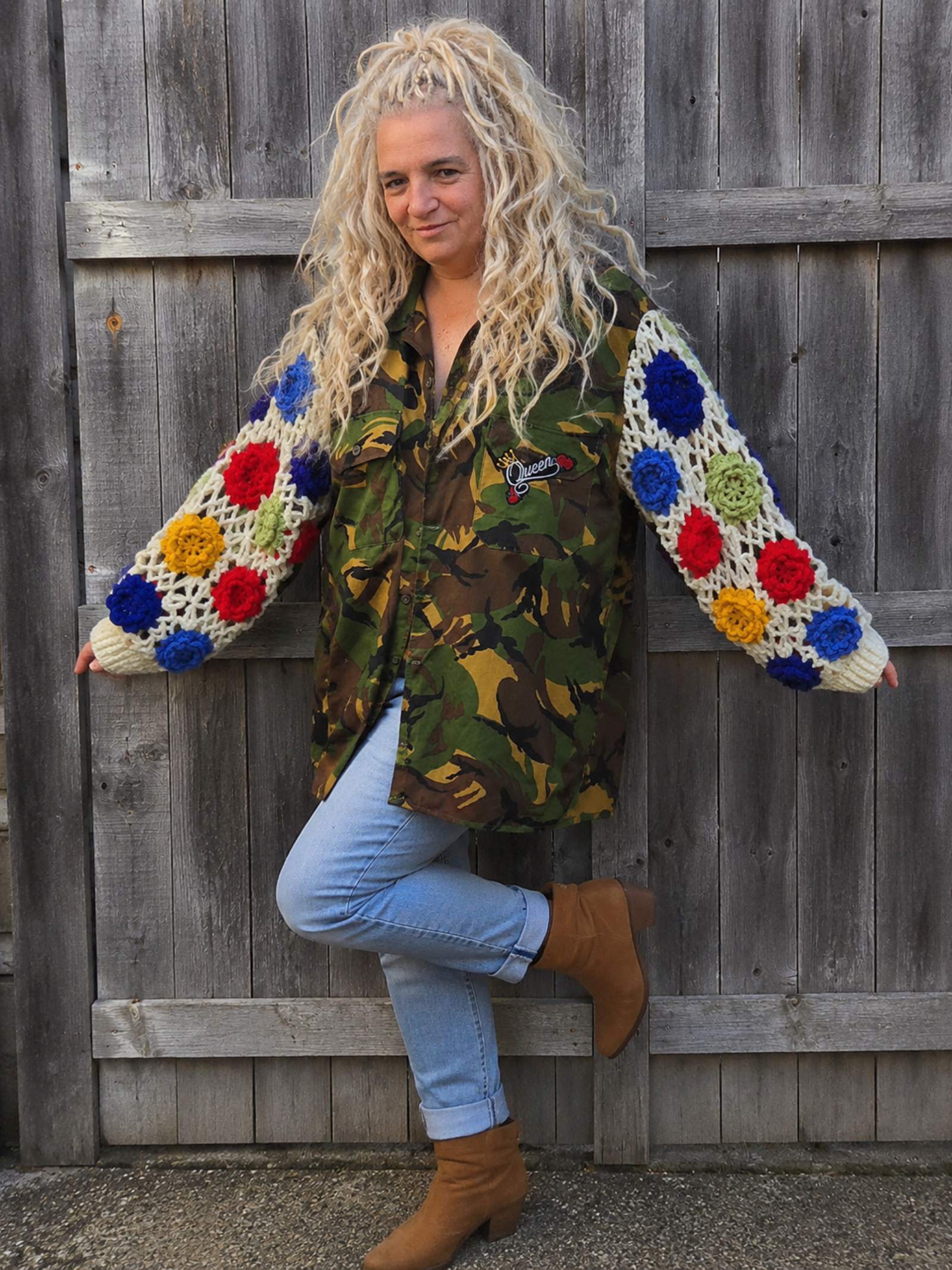 Upcycled camouflage jas met kleurrijke gehaakte bloemenmouwen, gedragen door model, voorkant, one of a kind boho jas.