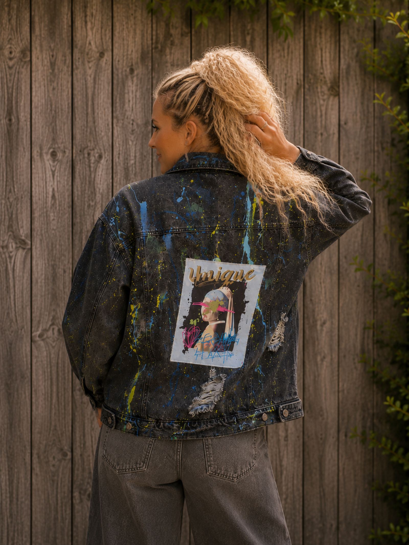 Model draagt One of a Kind zwart upcycled spijkerjasje met Unique kunstpatch, verfspetters en handgemaakte details | Old New Atelier