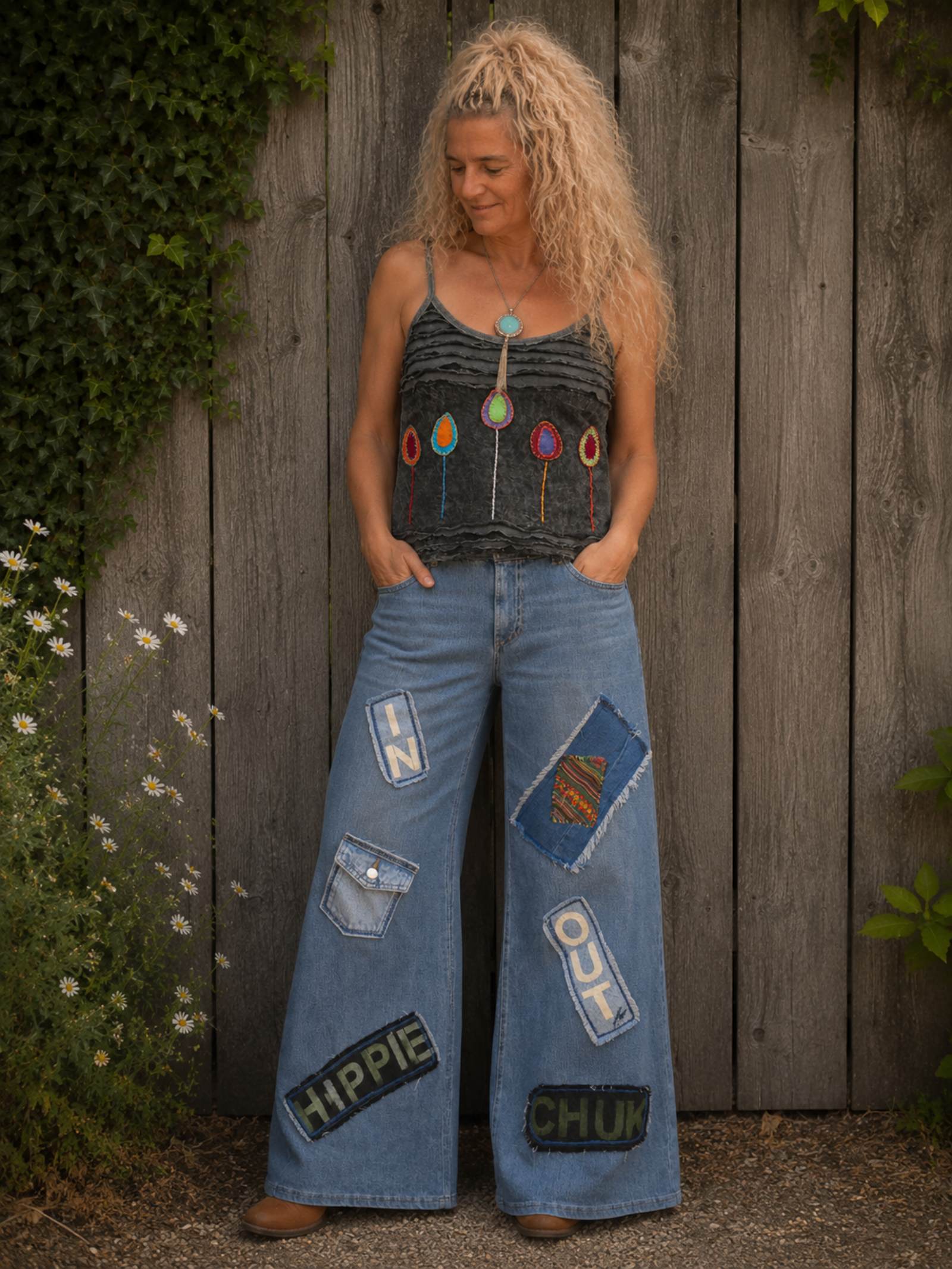 Grijs handgemaakt boho topje gedragen op een upcycled denim broek, voorkant met kleurrijke applicaties.