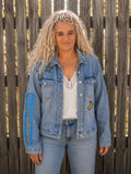 Vrouwelijk model draagt een handgemaakt upcycled denim jasje met Fly Free patch van Old New Atelier.