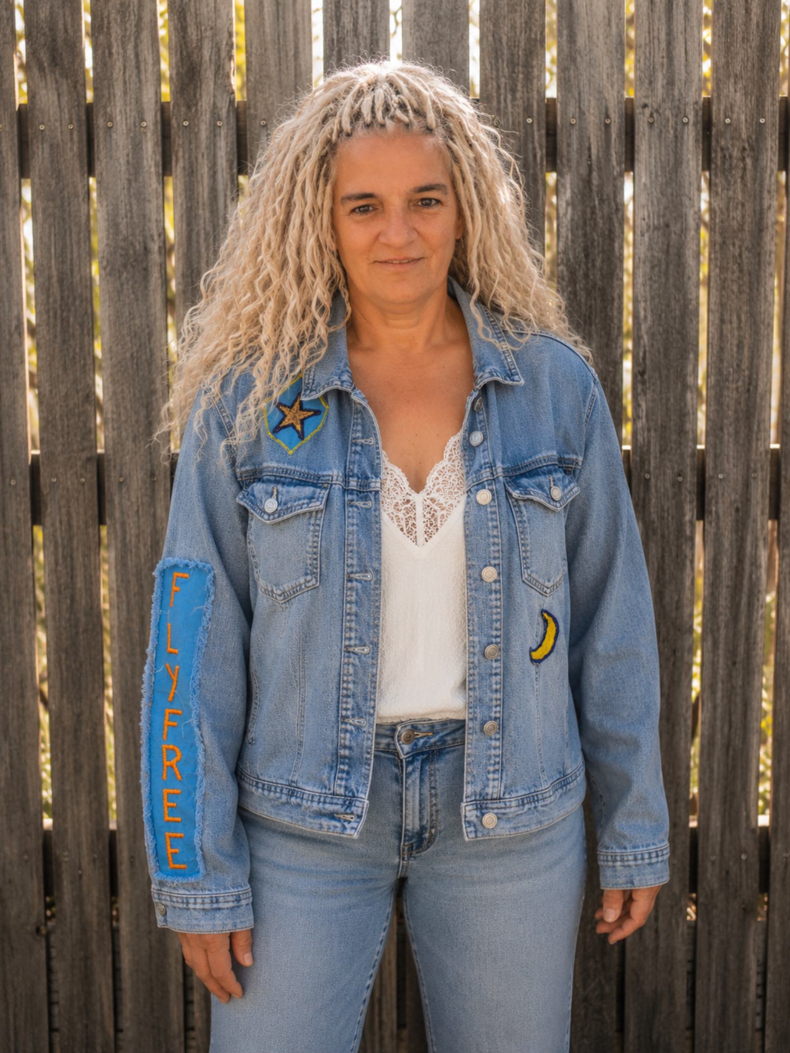 Vrouwelijk model draagt een handgemaakt upcycled denim jasje met Fly Free patch van Old New Atelier.