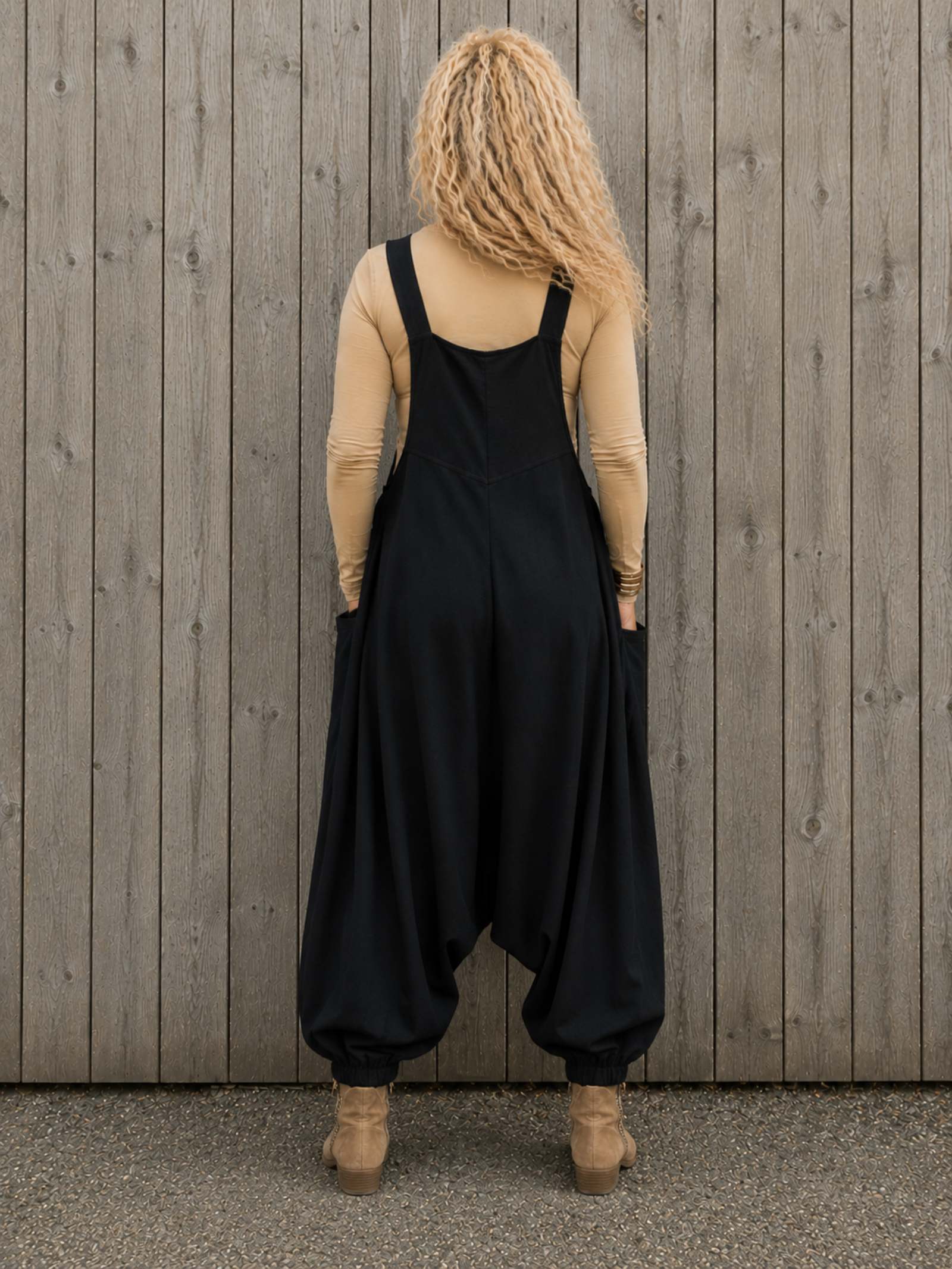 Achterkant van zwarte boho tuinbroek met harem pasvorm, elastische broekspijpen en verstelbare schouderbanden.