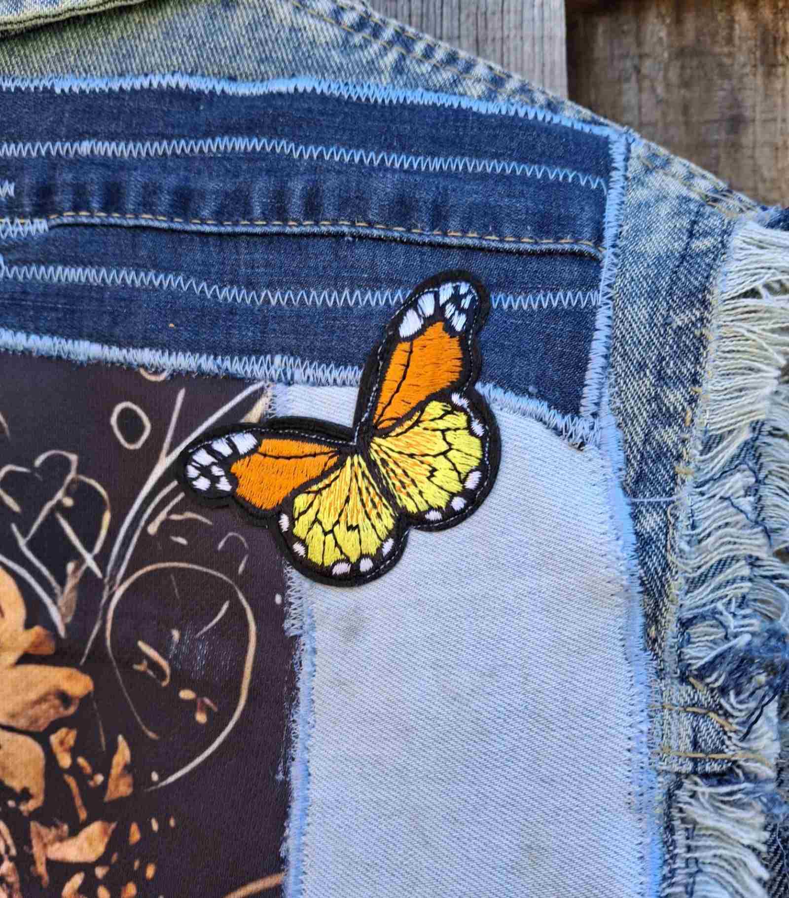 Detail van butterfly patch op upcycled denim gilet