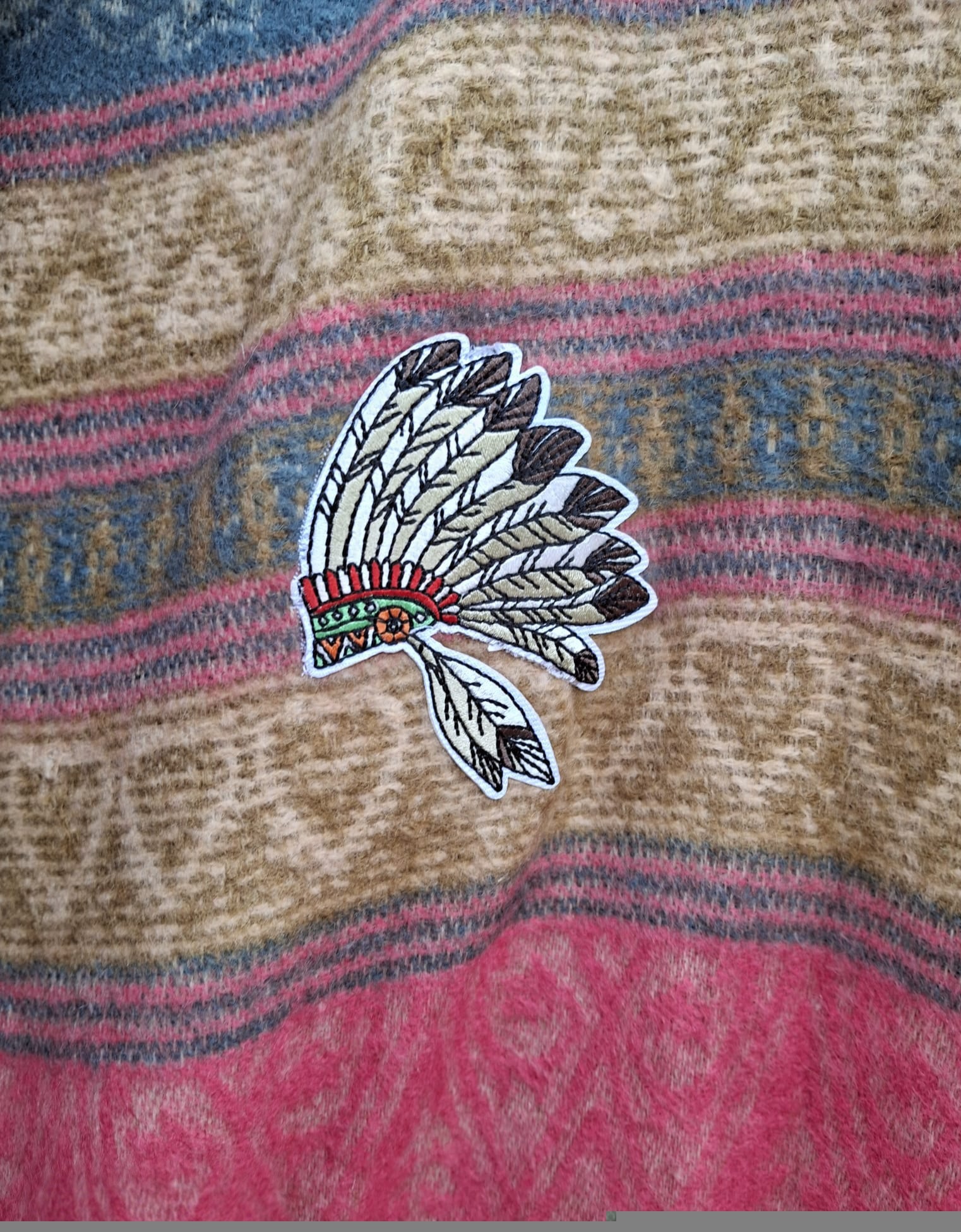 Detail van geborduurde veren patch op boho festival vest met zachte geweven stof