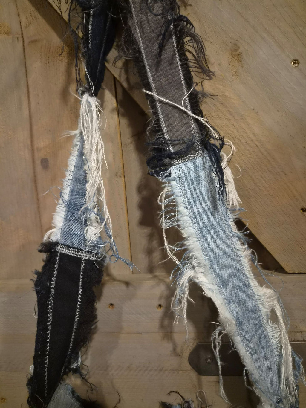 Detail van handgemaakte patchwork denim schouderband met rafelranden