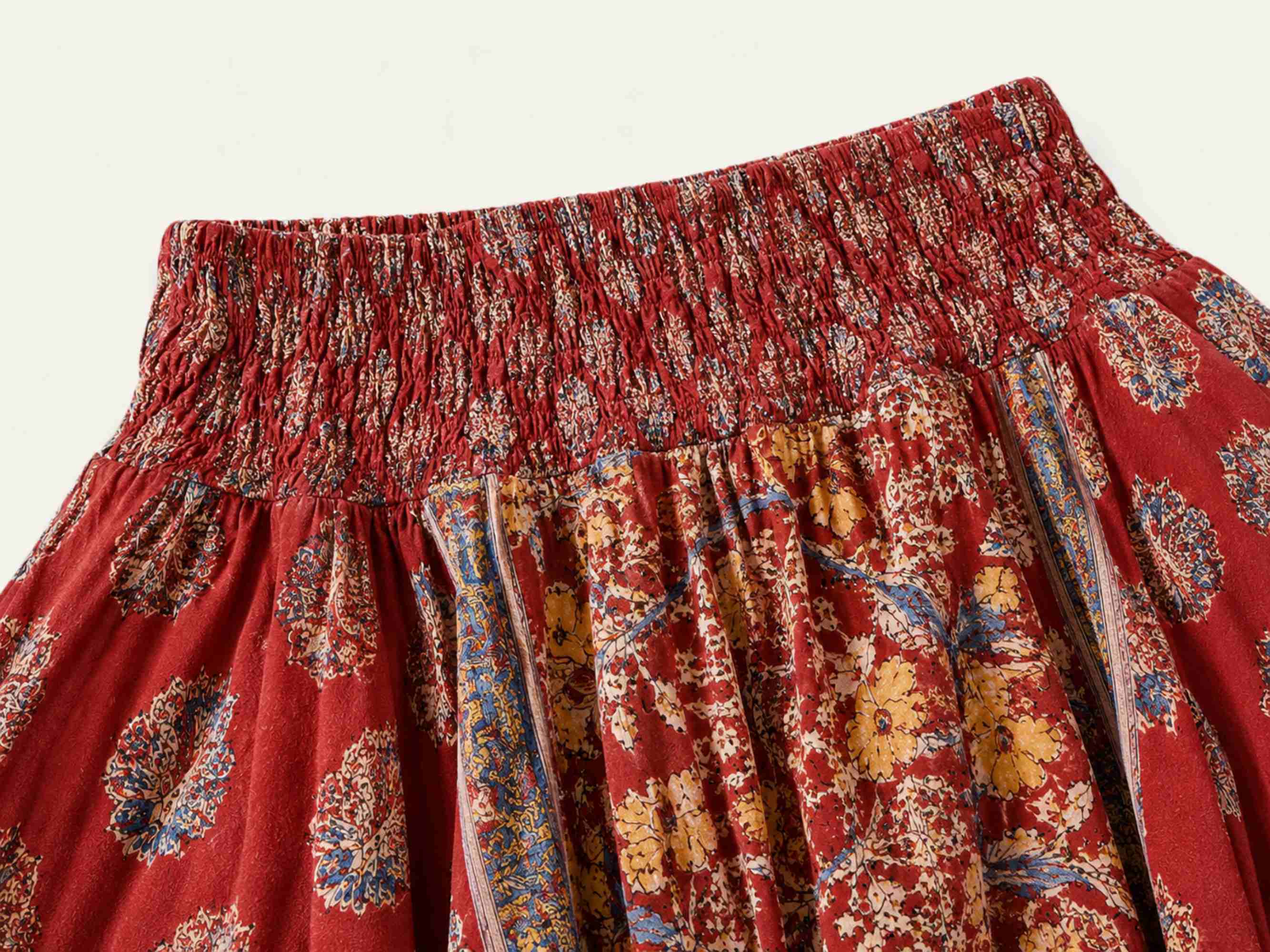Detail van de elastische stretch tailleband van de rode asymmetrische boho rok met handgemaakt patchworkdessin.