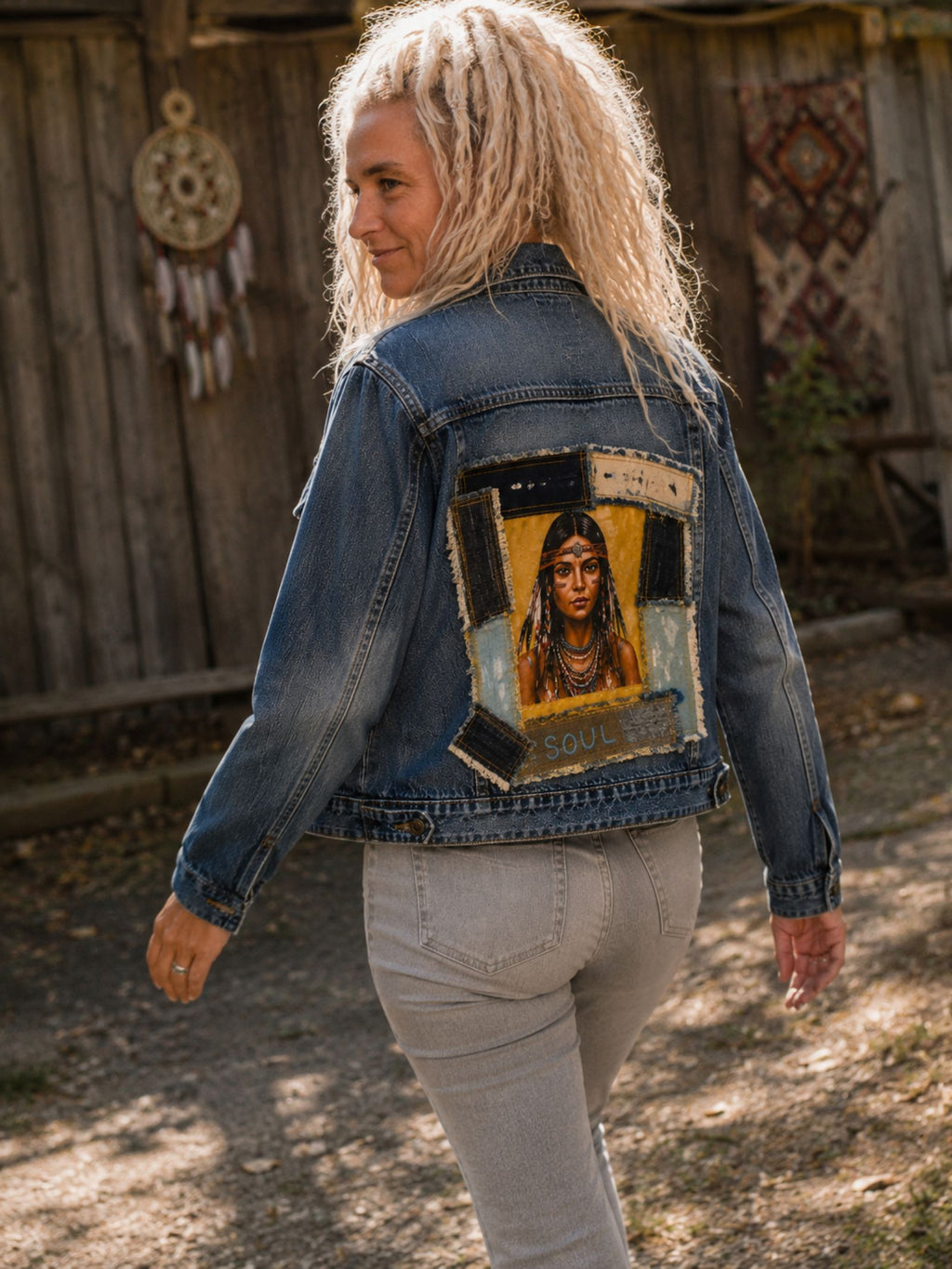 Model draagt het One of a Kind upcycled denim jasje met Indian Soul artwork tijdens een wandeling, waardoor de handgemaakte achterkant mooi zichtbaar is.