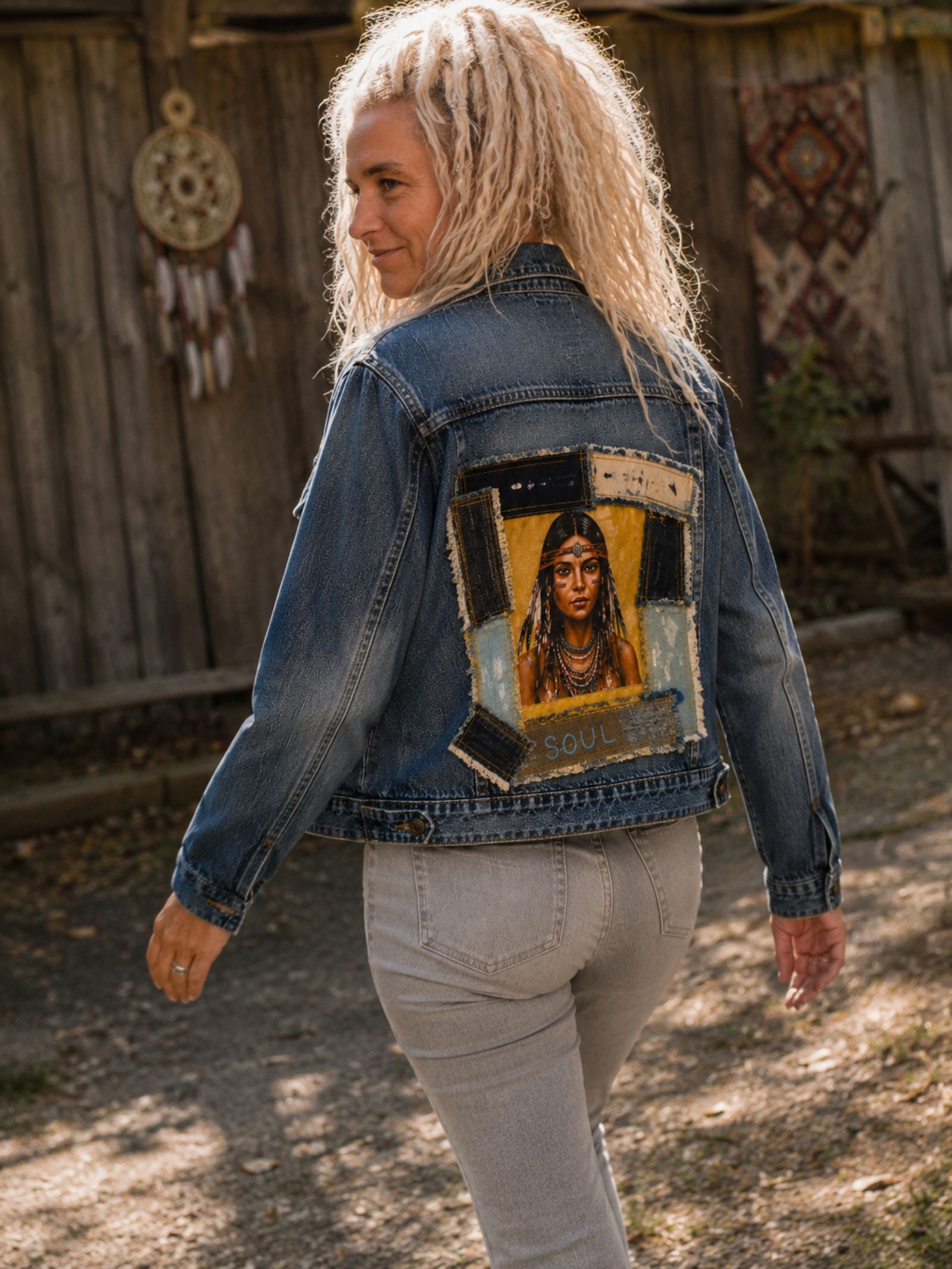 Model draagt het One of a Kind upcycled denim jasje met Indian Soul artwork tijdens een wandeling, waardoor de handgemaakte achterkant mooi zichtbaar is.