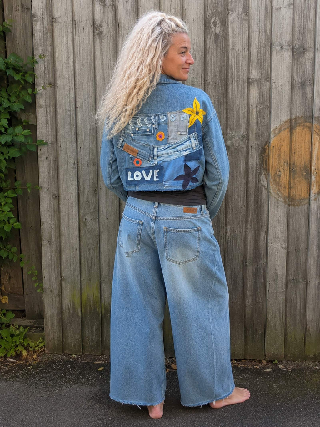 One of a Kind upcycled denim crop jasje gedragen door model met handgemaakt denim kunstwerk op de achterkant - Old New Atelier.