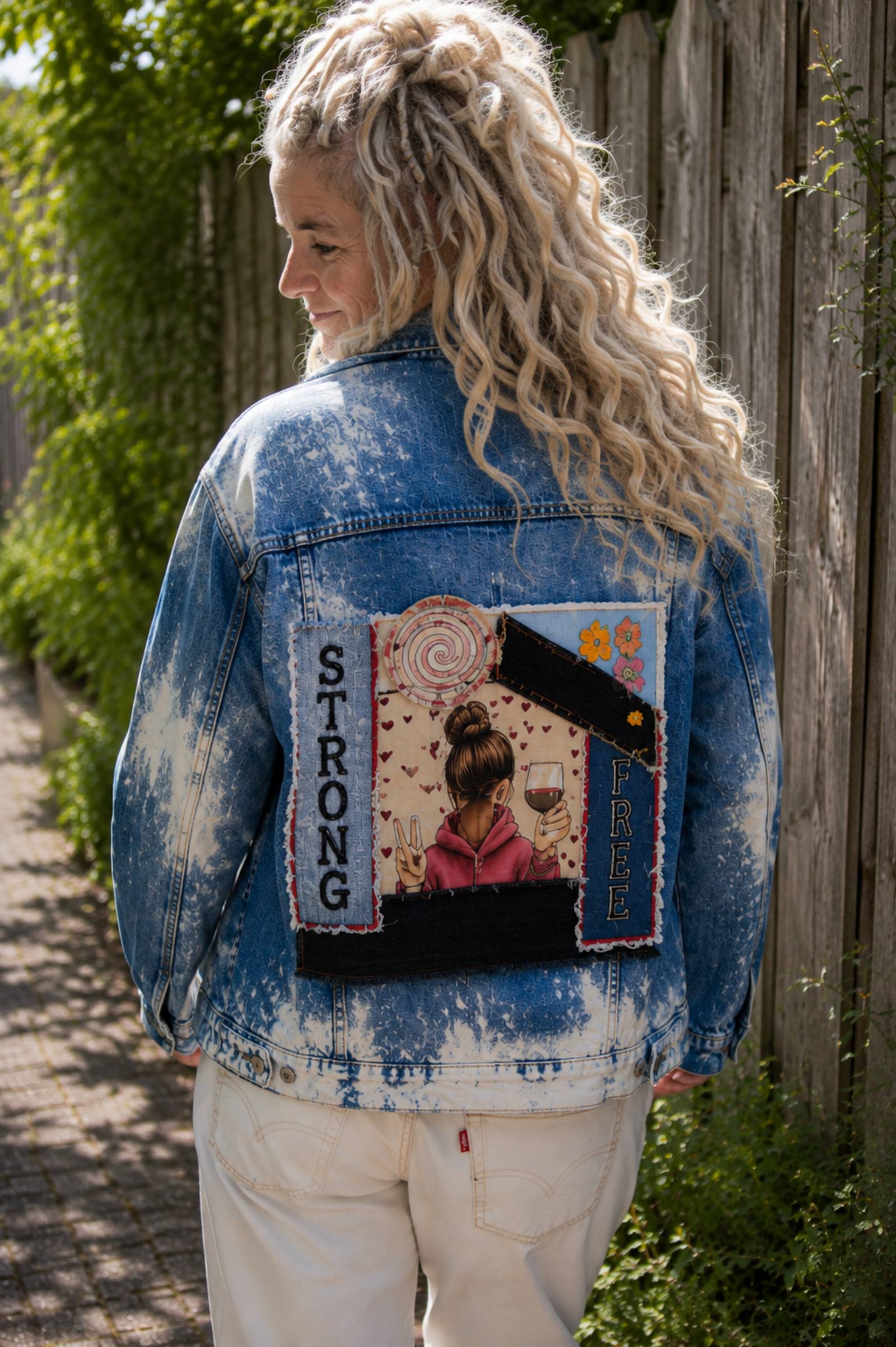 Strong & Free upcycled denim jasje gedragen tijdens het lopen met rugkunstwerk zichtbaar