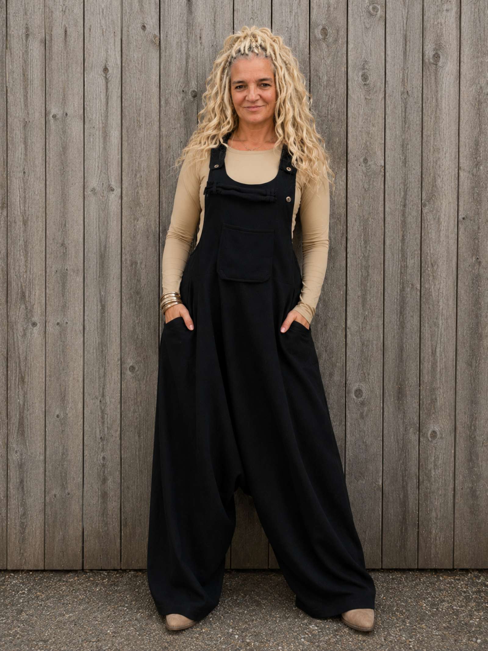 Zwarte boho tuinbroek van 100% katoen gedragen door model – oversized harem jumpsuit met steekzakken en verstelbare schouderbanden.