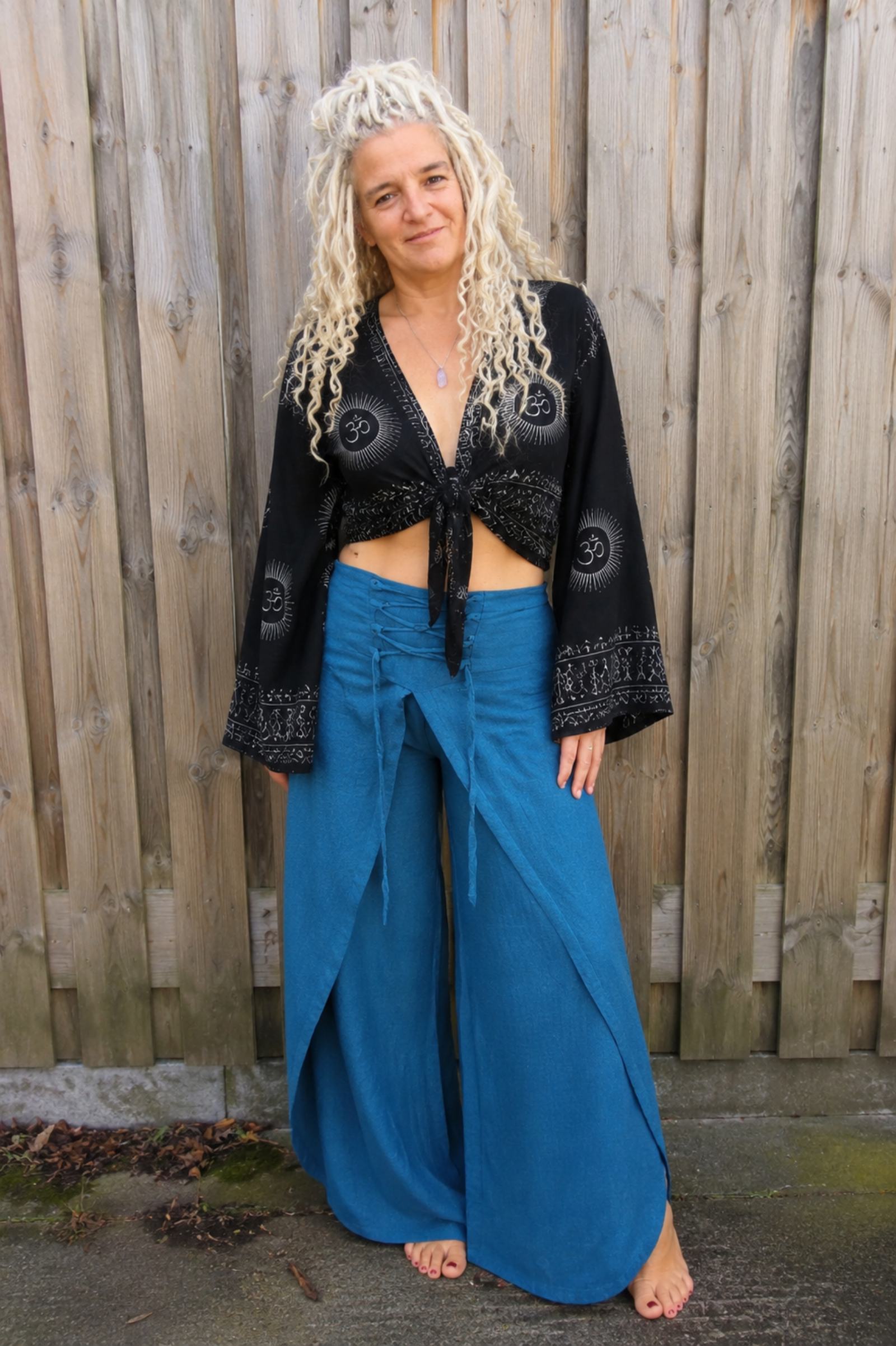 Model draagt zwarte boho wikkelblouse met wijde mouwen en blauwe omslagbroek van 100% katoen – Old New Atelier