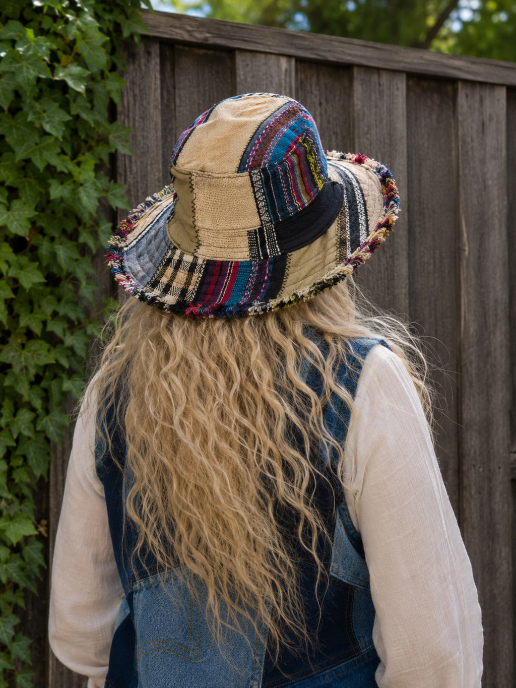 Achteraanzicht van een handgemaakte patchwork hoed uit Nepal met unieke patchworkstoffen en rafelrand.