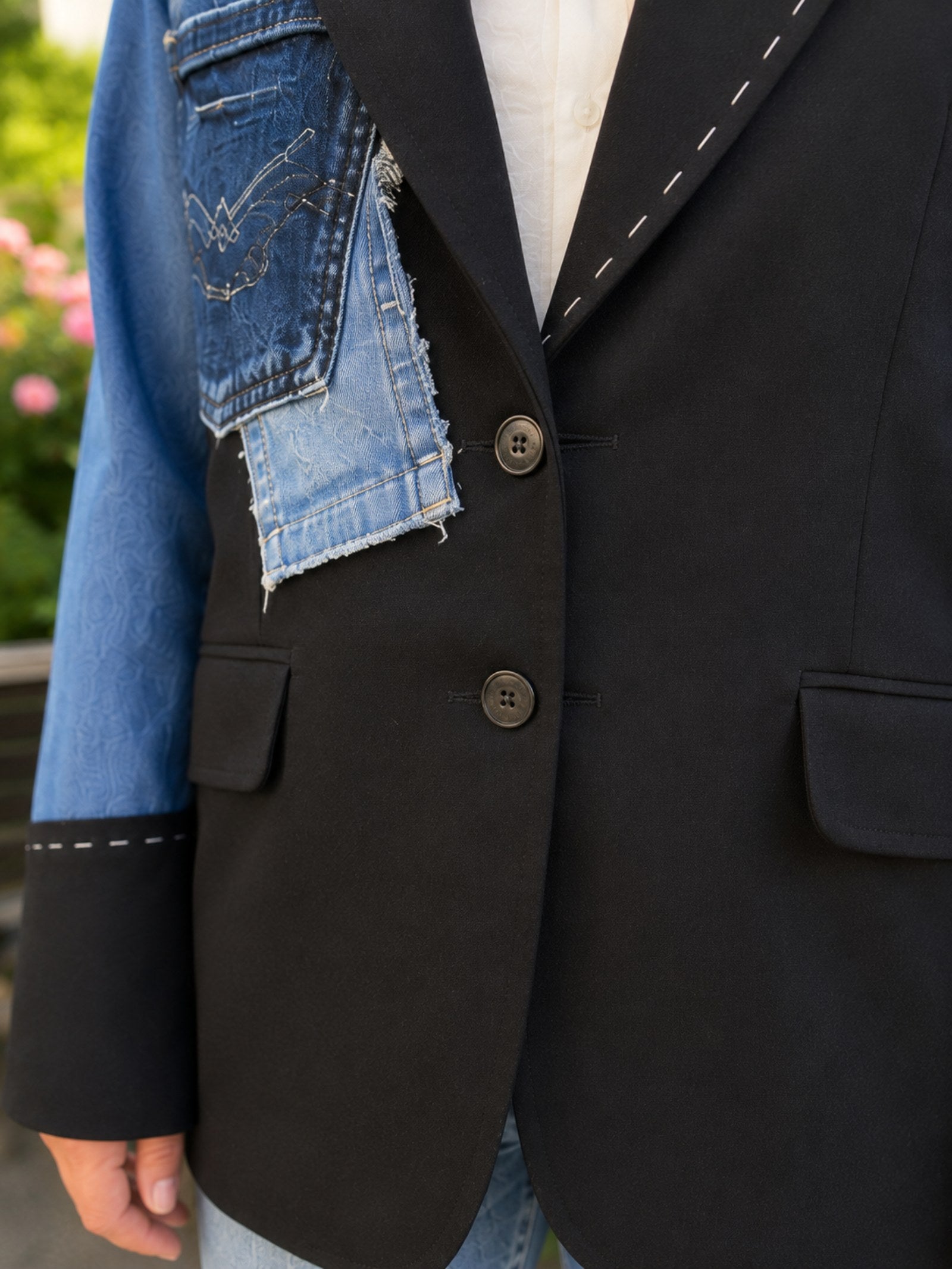 Detail van de knoopsluiting en denim patchwork op een handgemaakt One of a Kind colbert