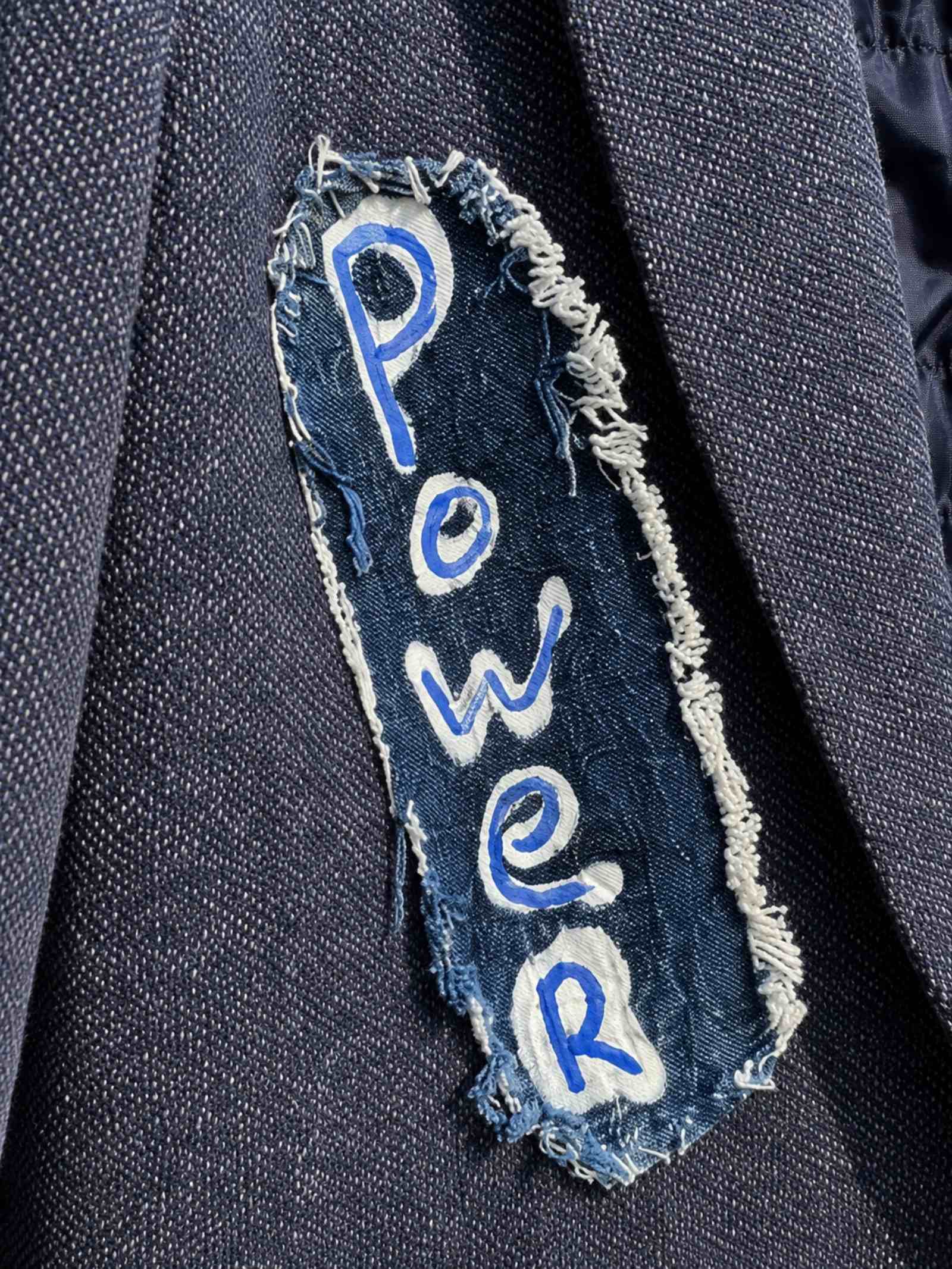 Detail van handgeschilderde Power patch op One of a Kind blazer met rafelrand - Old New Atelier
