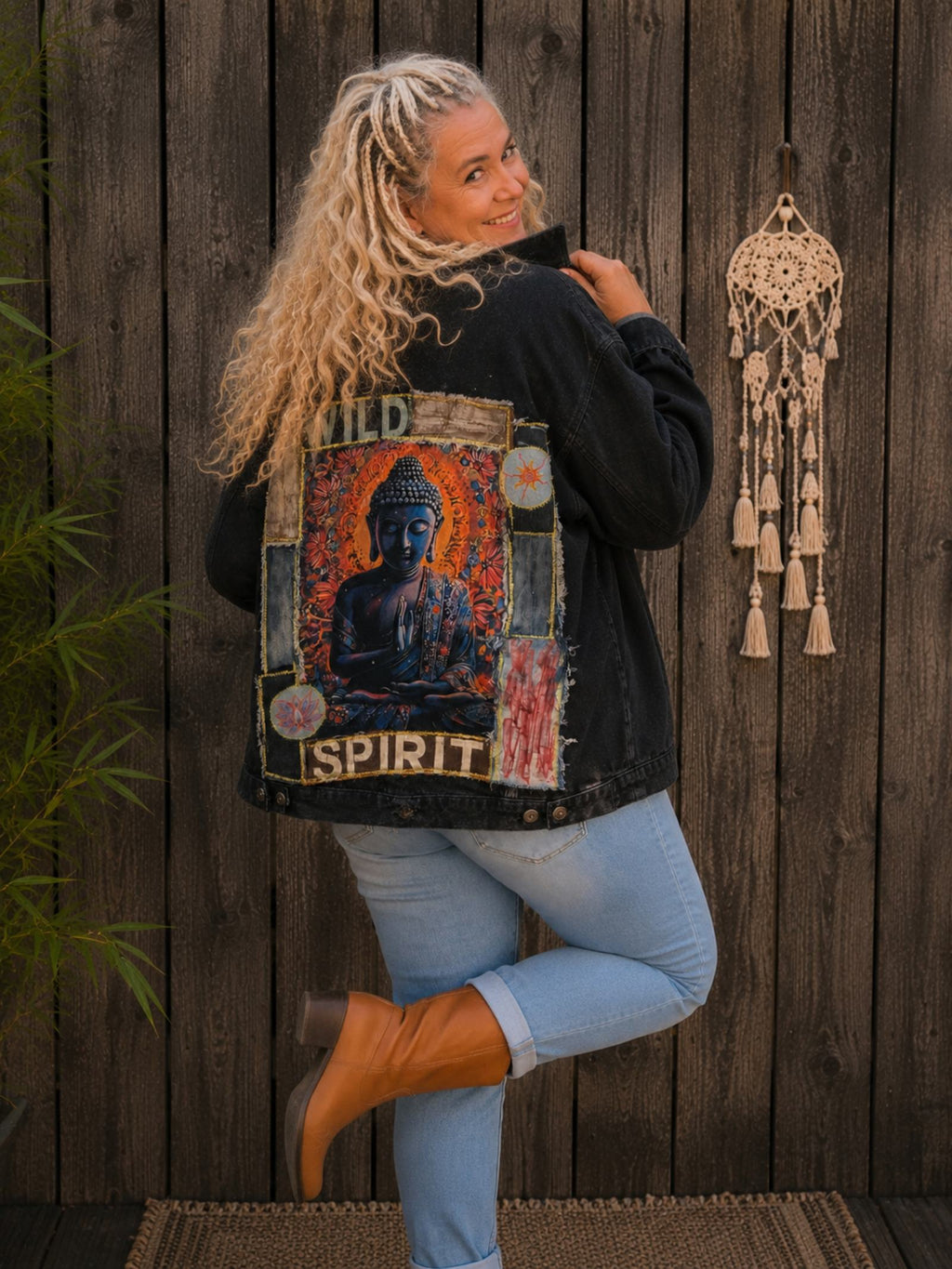 Vrouwelijk model in speelse pose draagt een oversized Wild Spirit Buddha denim jasje met handgemaakte details van Old New Atelier.