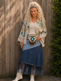 Handgemaakt boho heuptasje van koeienhuid met turquoise steen gedragen door model voor houten schutting | Old New Atelier