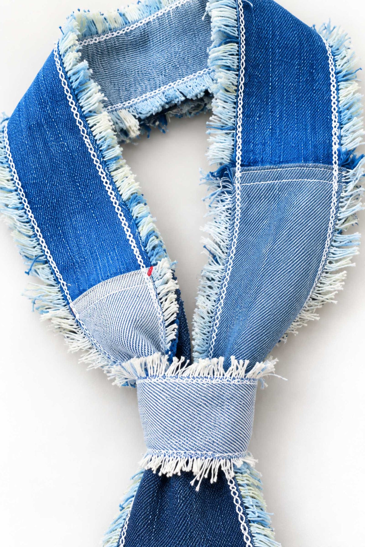 Detail van handgemaakte denim knoop en zichtbare rafelafwerking
