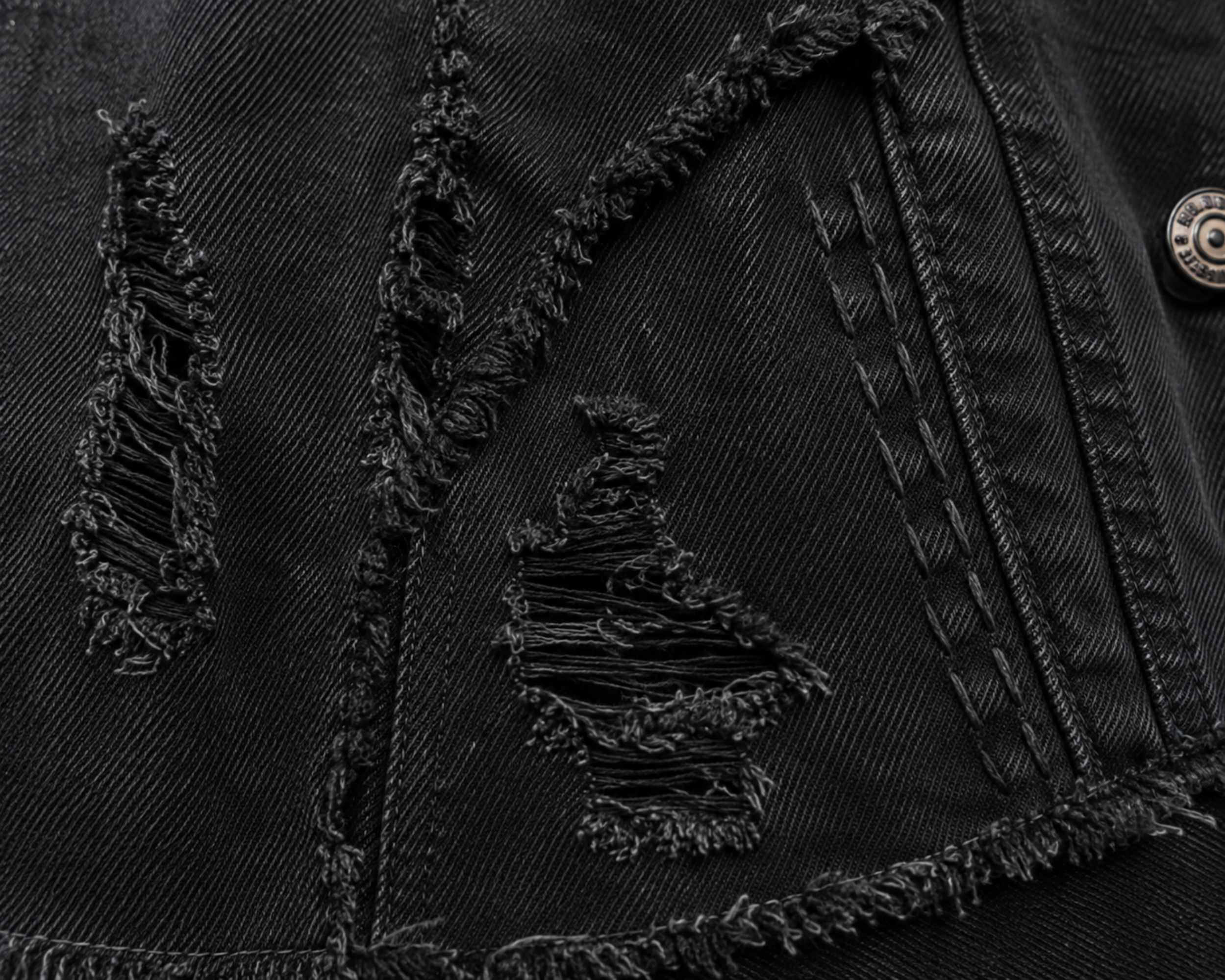 Close-up van de destroyed details in het zwarte denim jasje.