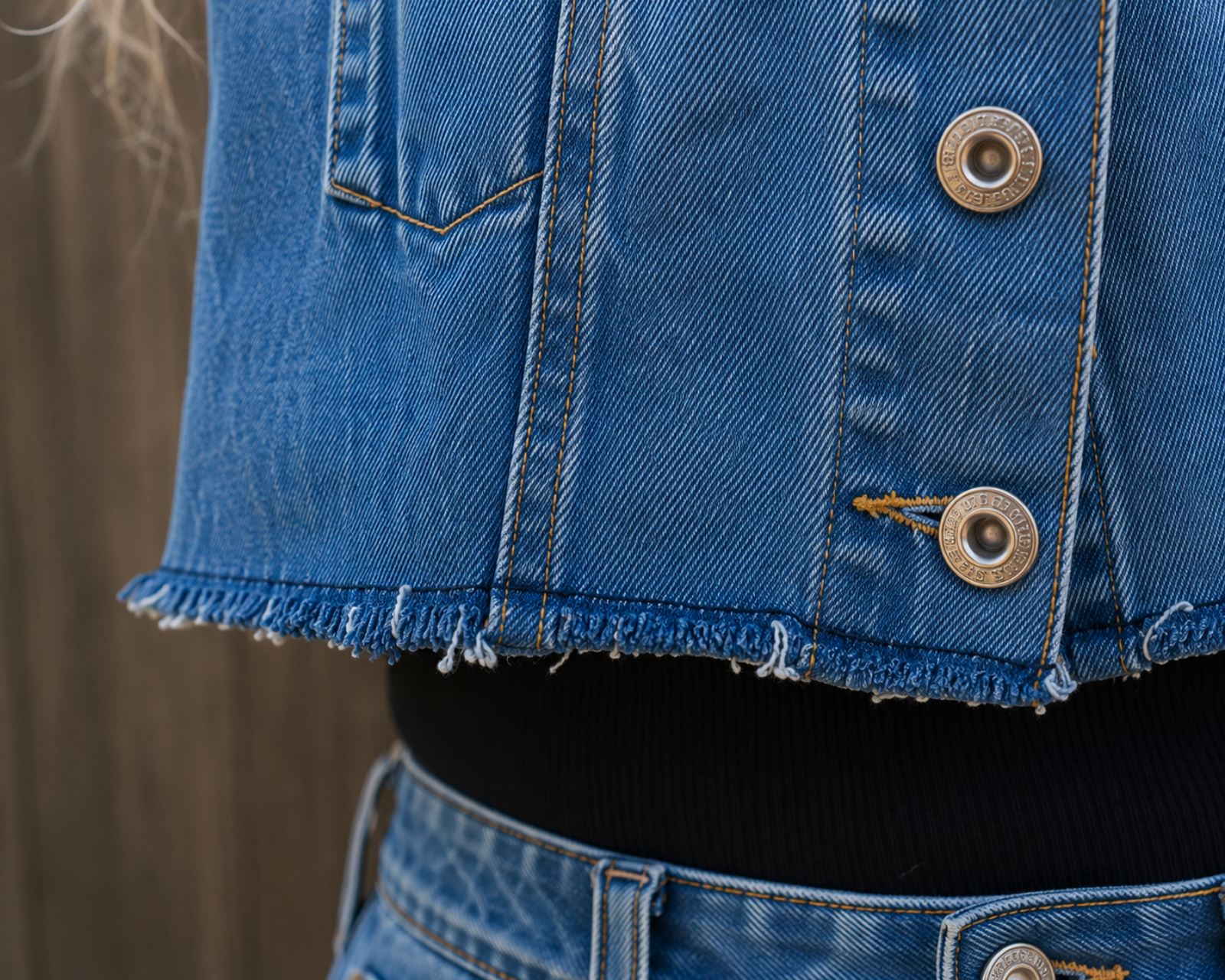 Close-up van de handgemaakte rafelzoom van een One of a Kind upcycled denim crop jasje van Old New Atelier.
