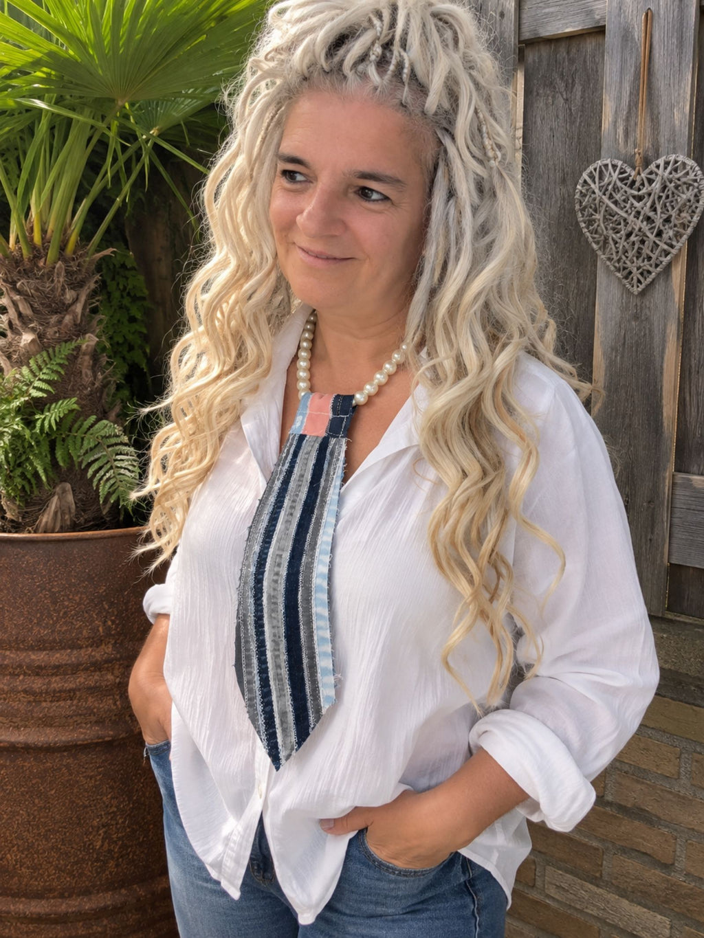 One of a Kind upcycled denim tie necklace met parelketting gedragen op witte blouse