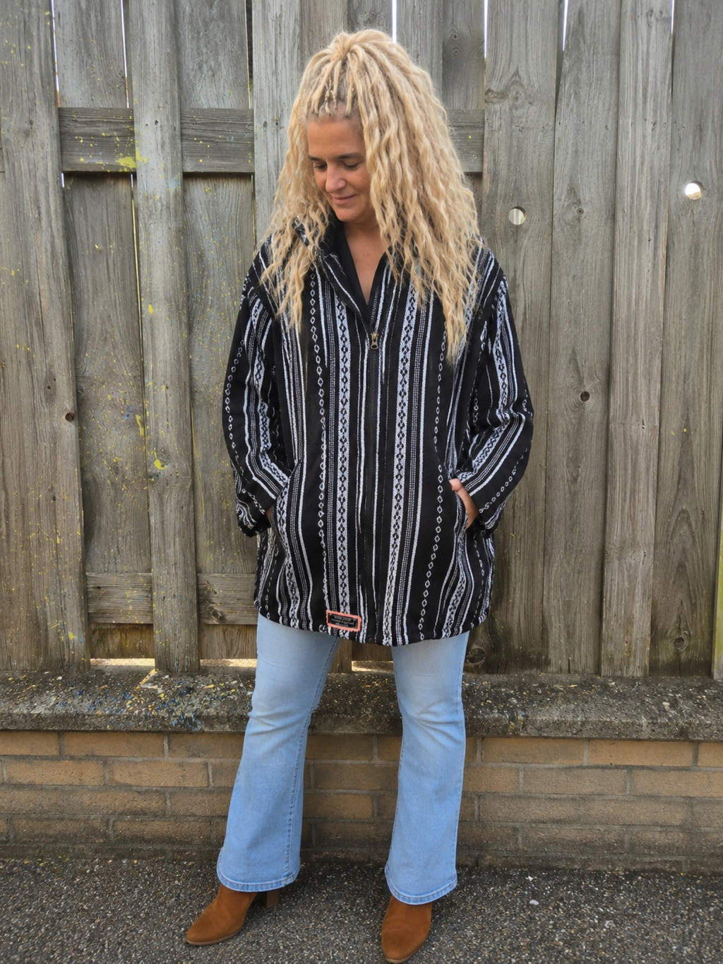 Handgemaakt zwart boho capuchonvest gedragen met oversized pasvorm en capuchon – Old New Atelier.