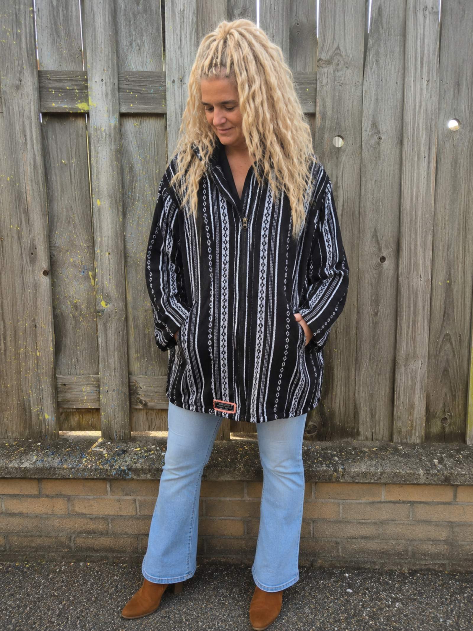 Handgemaakt zwart boho capuchonvest gedragen met oversized pasvorm en capuchon – Old New Atelier.