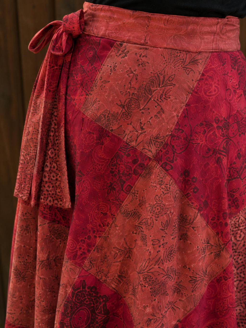 Detail van de verstelbare striksluiting van de rode wrap rok.