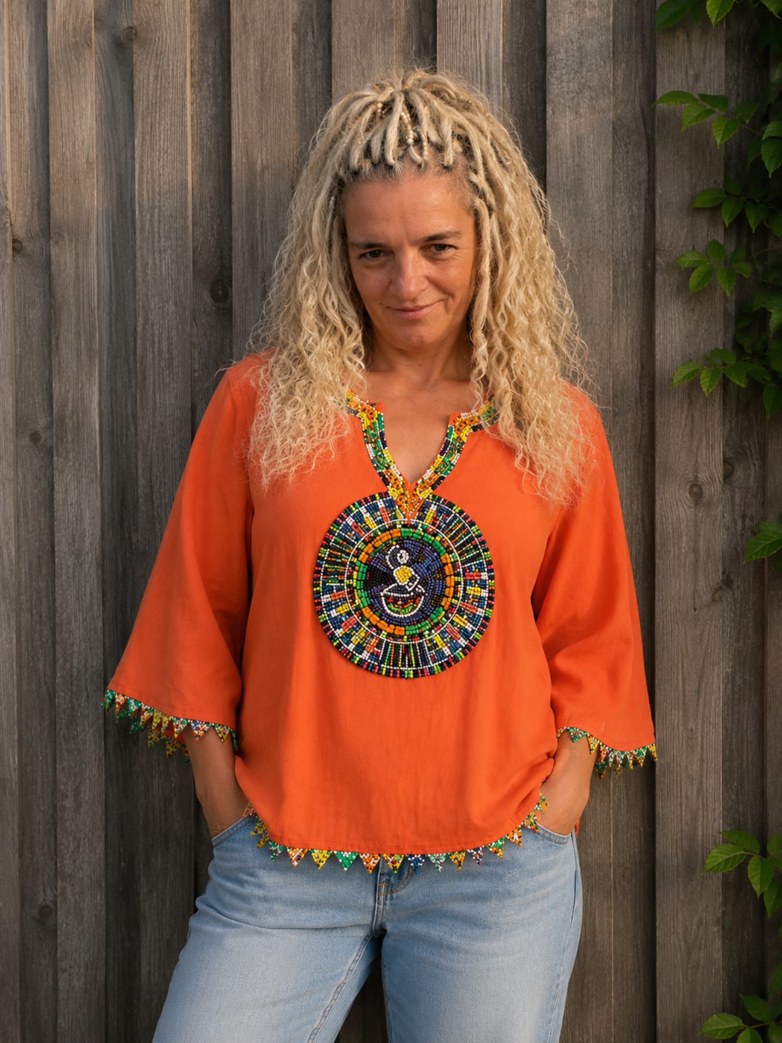 Oranje boho blouse met handgemaakt kleurrijk kralenborduursel gedragen door model – Old New Atelier