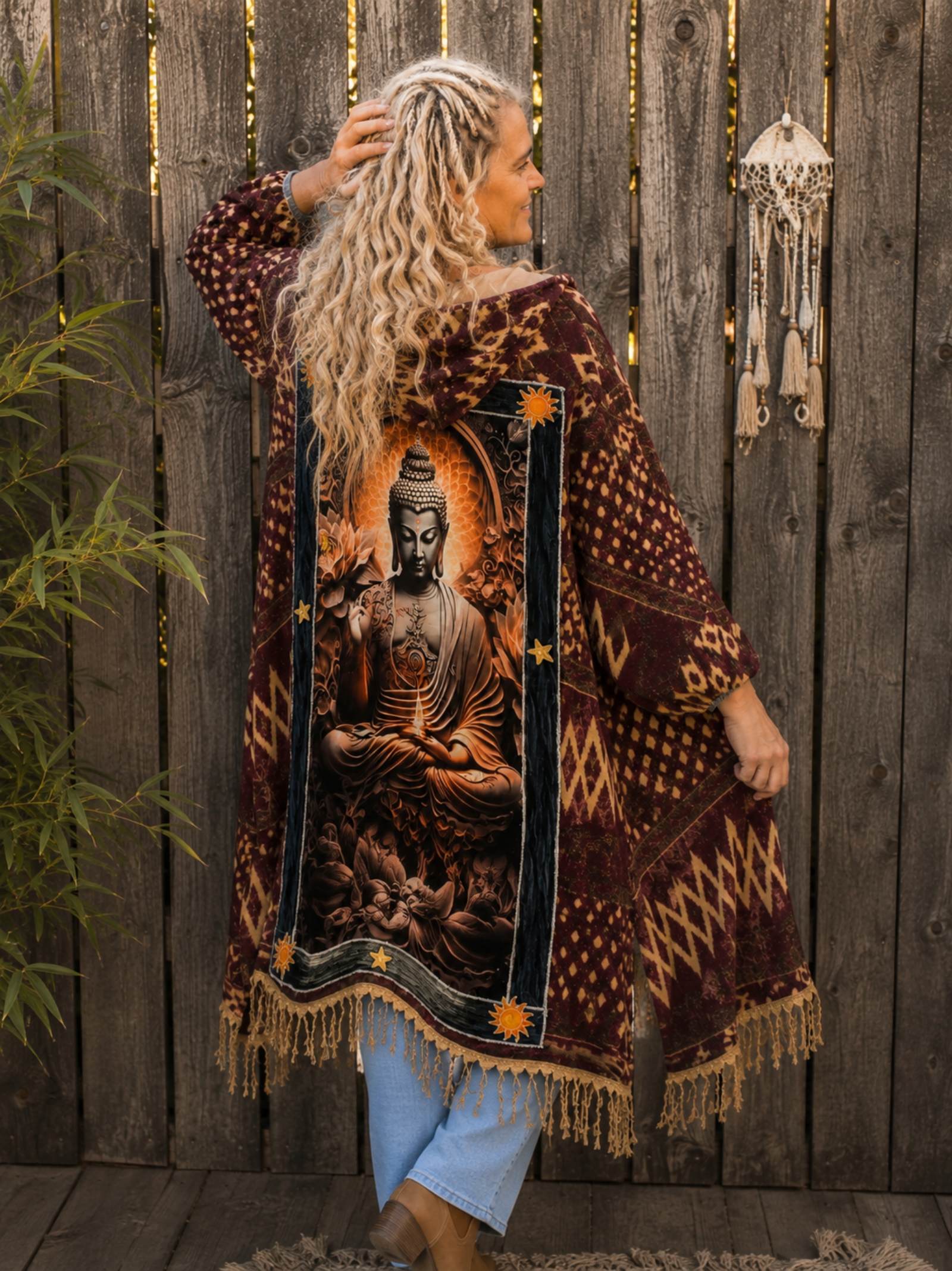 Vrouwelijk model draagt een handgemaakte boho poncho met Buddha artwork op de achterkant en franjes van Old New Atelier.