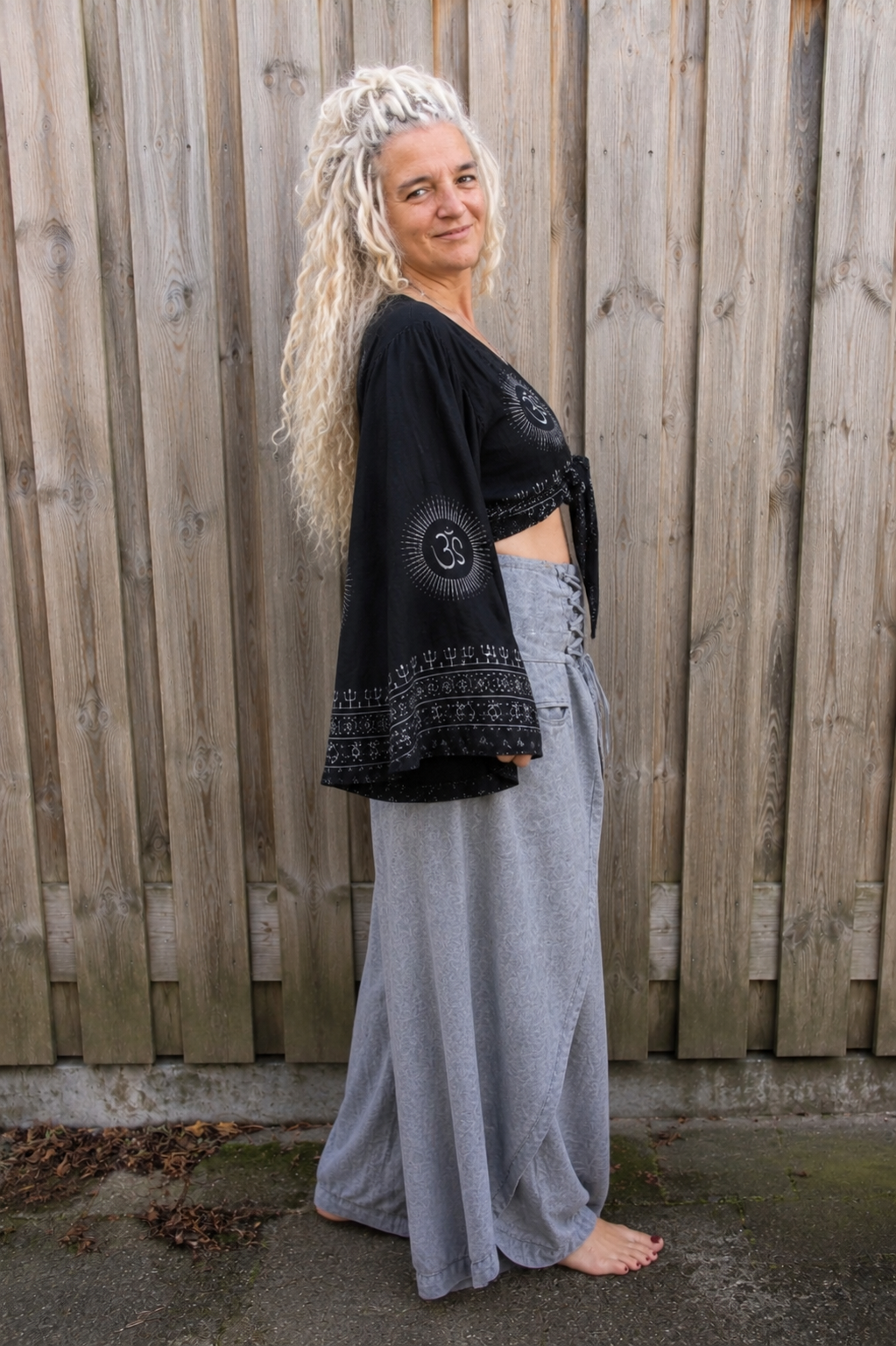 Zijaanzicht van zwarte boho wikkelblouse met wijde mouwen en grijze omslagbroek van 100% katoen – Old New Atelier