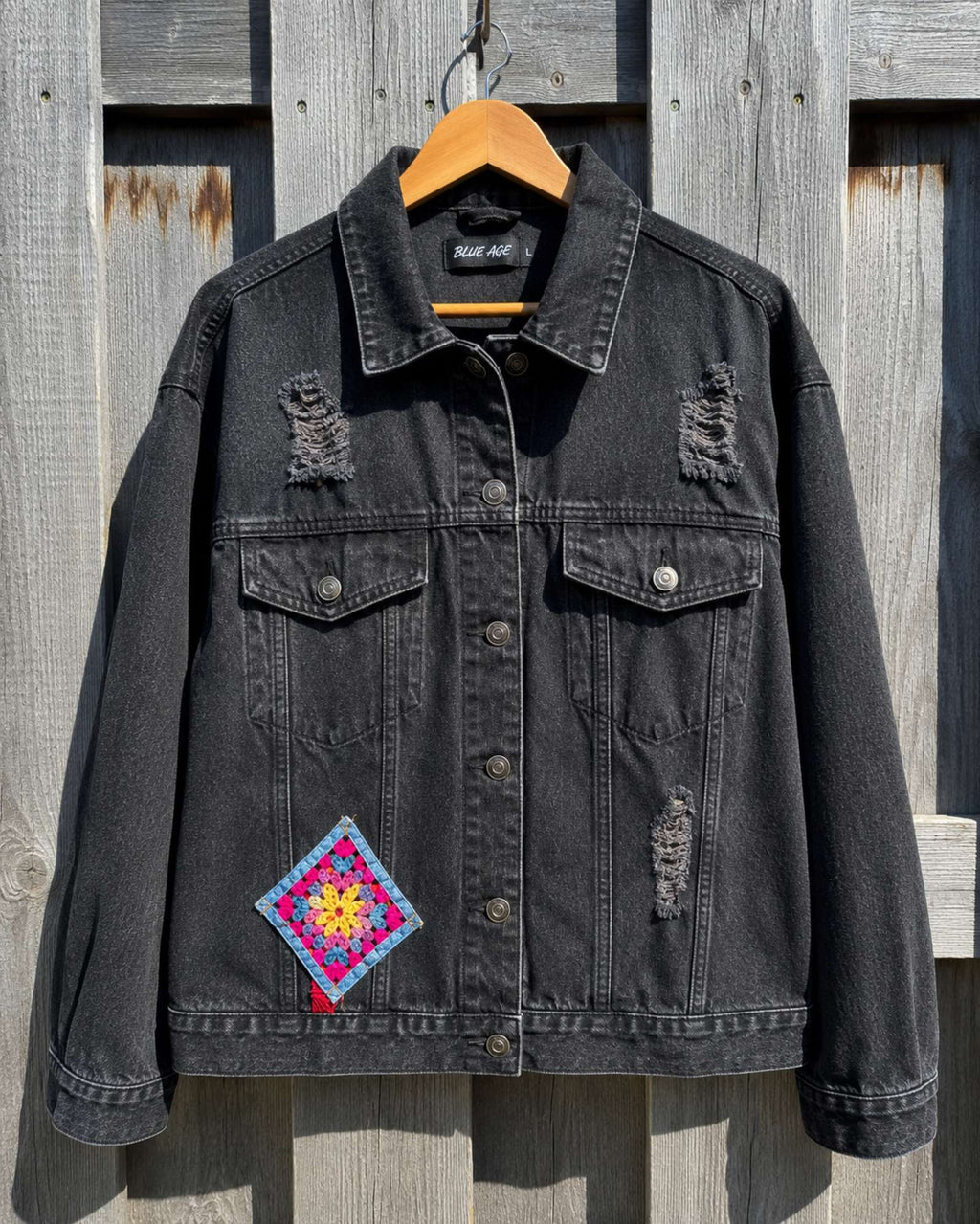 One of a Kind zwart denim jasje met gehaakte granny square op hanger.