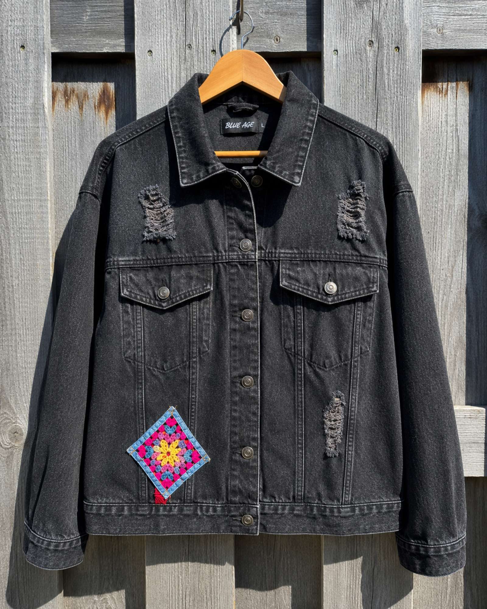 One of a Kind zwart denim jasje met gehaakte granny square op hanger.