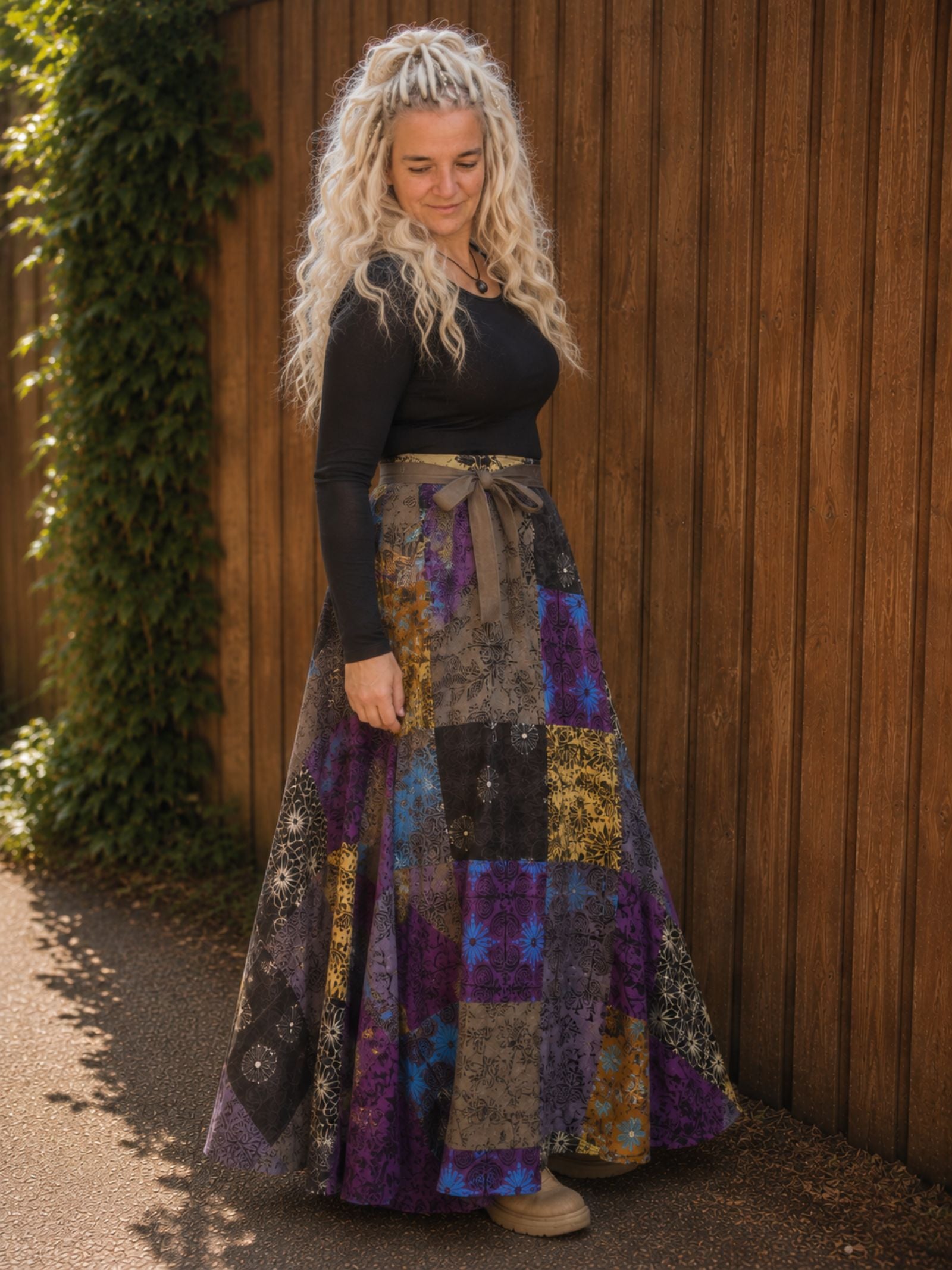 Schuin vooraanzicht van paarse boho patchwork wrap rok met overslag en striksluiting