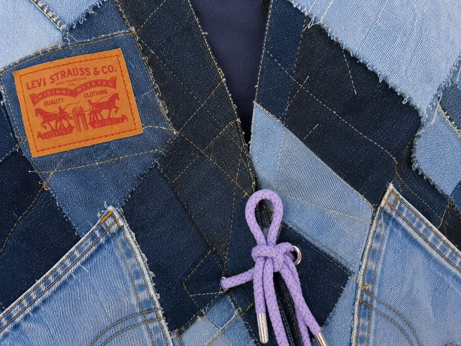 Close-up van het handgemaakte denim patchwork op de voorkant van Blue Nomad.