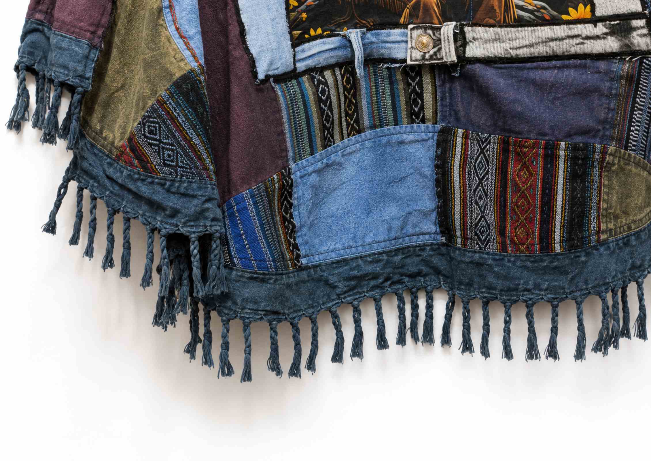 Handgemaakte franjes en patchwork details van boho poncho