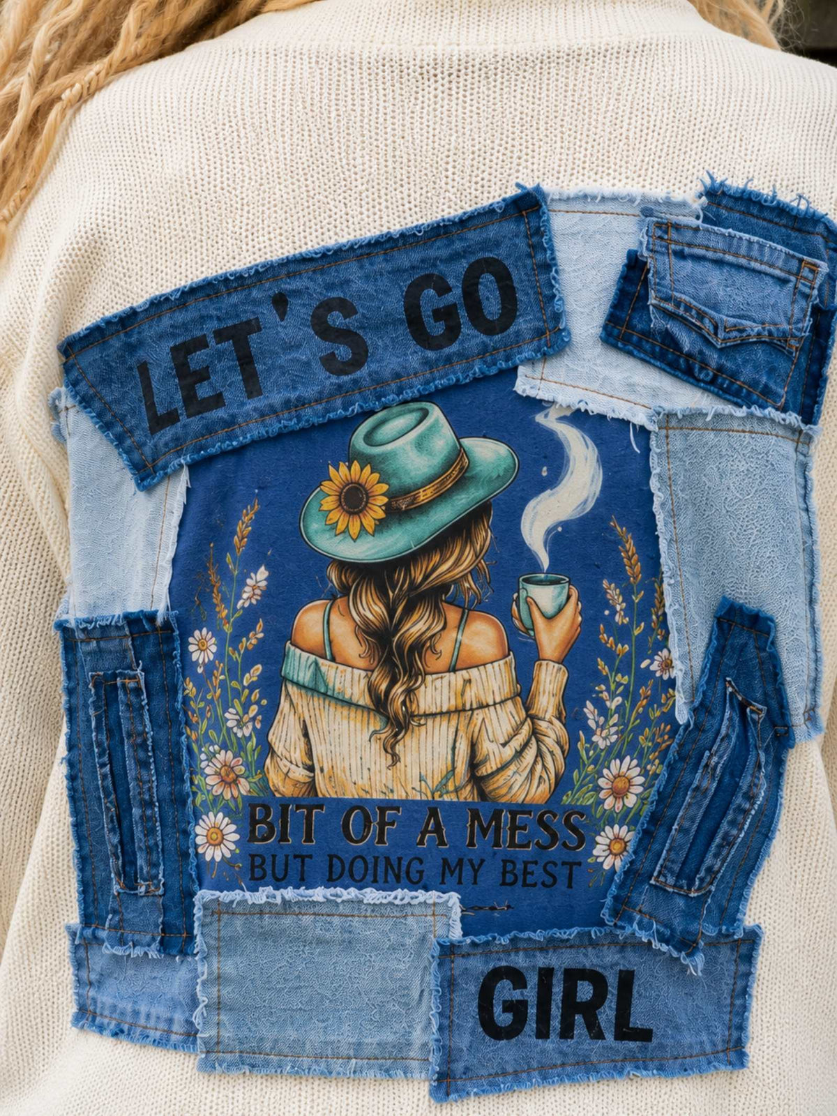 Close-up Desert Soul rugkunstwerk met Let's Go Girl en gelaagde denim details