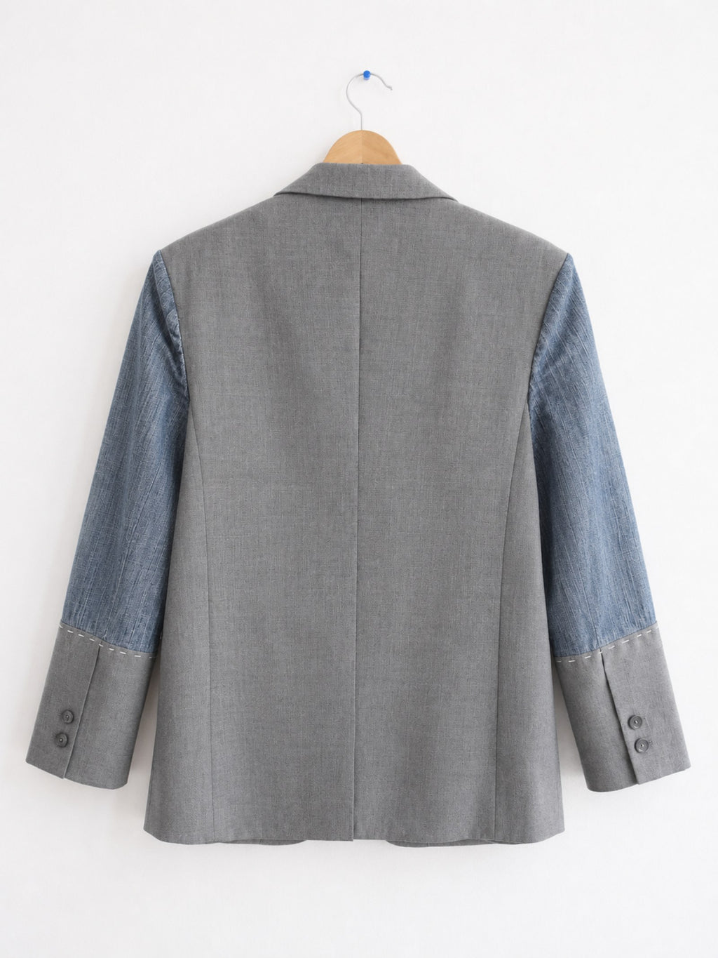 Achterkant van handgemaakte upcycled blazer met denim mouwen
