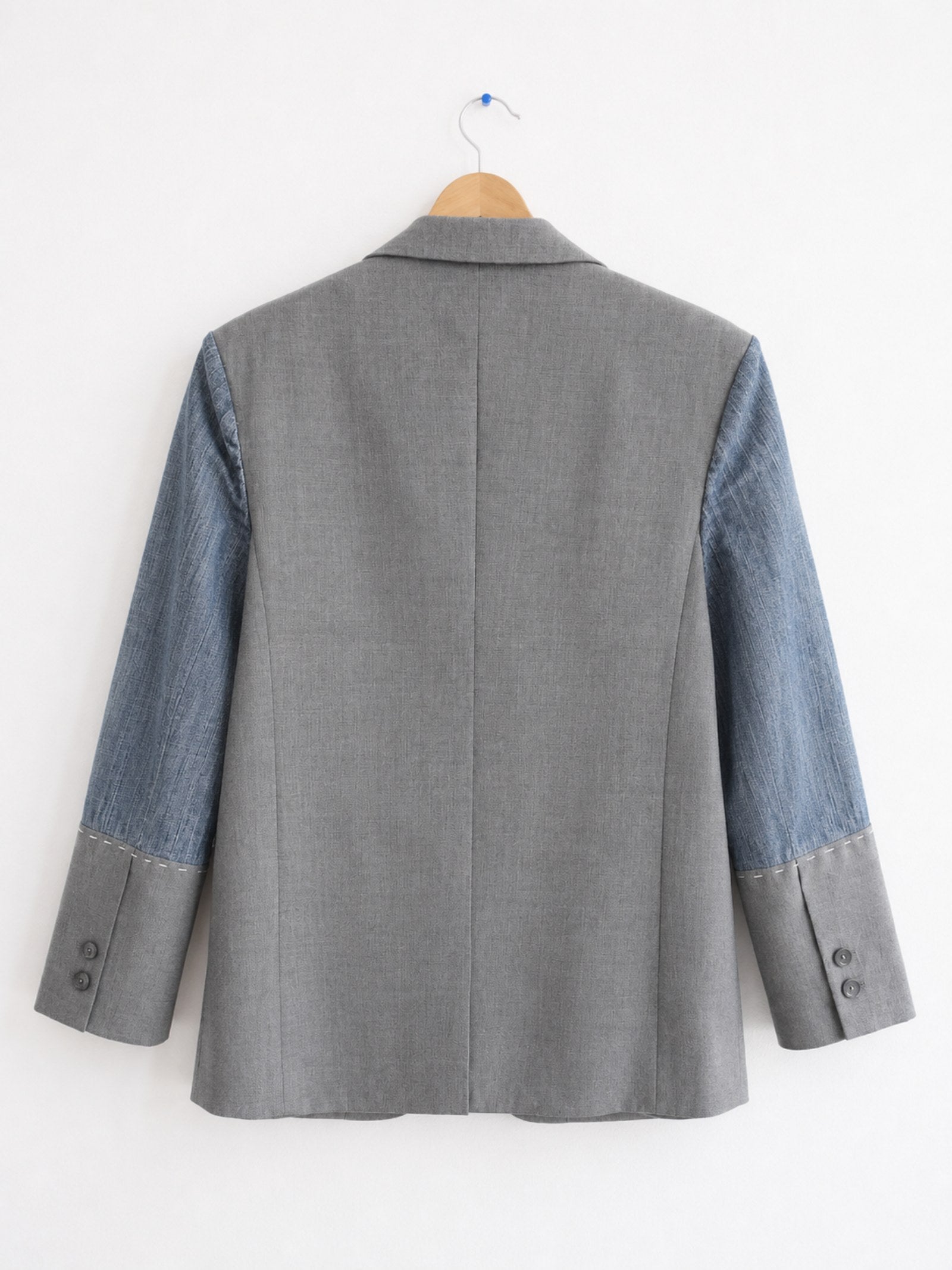 Achterkant van handgemaakte upcycled blazer met denim mouwen