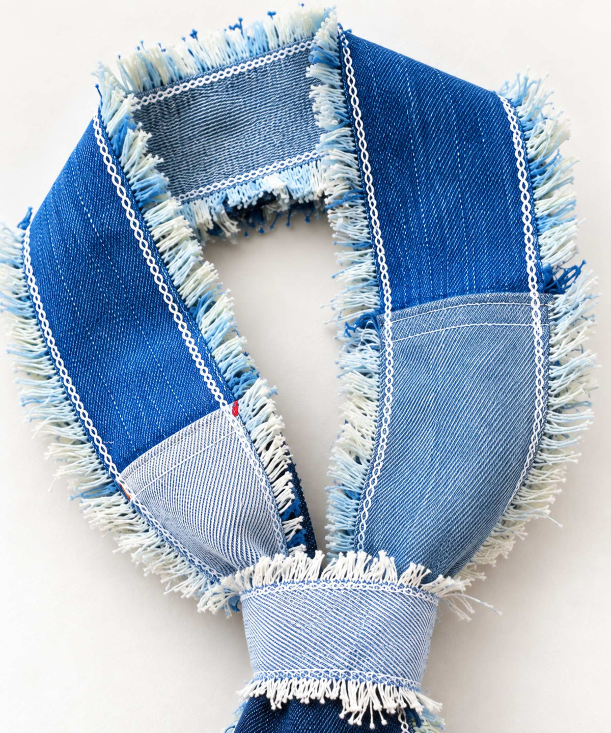 Detail van patchwork denim halsgedeelte met verschillende wassingen en rafelranden