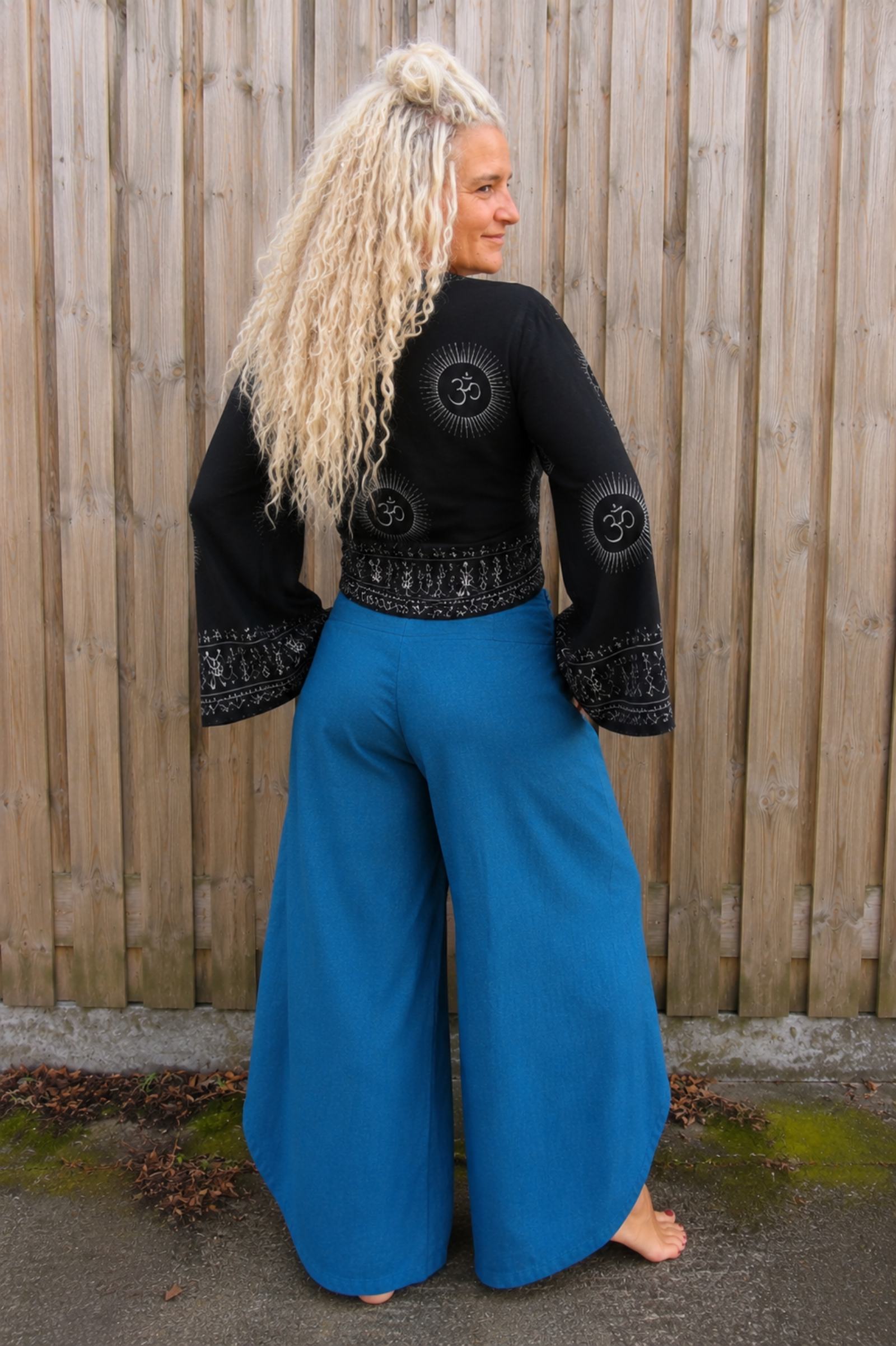 Achterkant van zwarte boho wikkelblouse met wijde mouwen gecombineerd met blauwe omslagbroek van 100% katoen – Old New Atelier