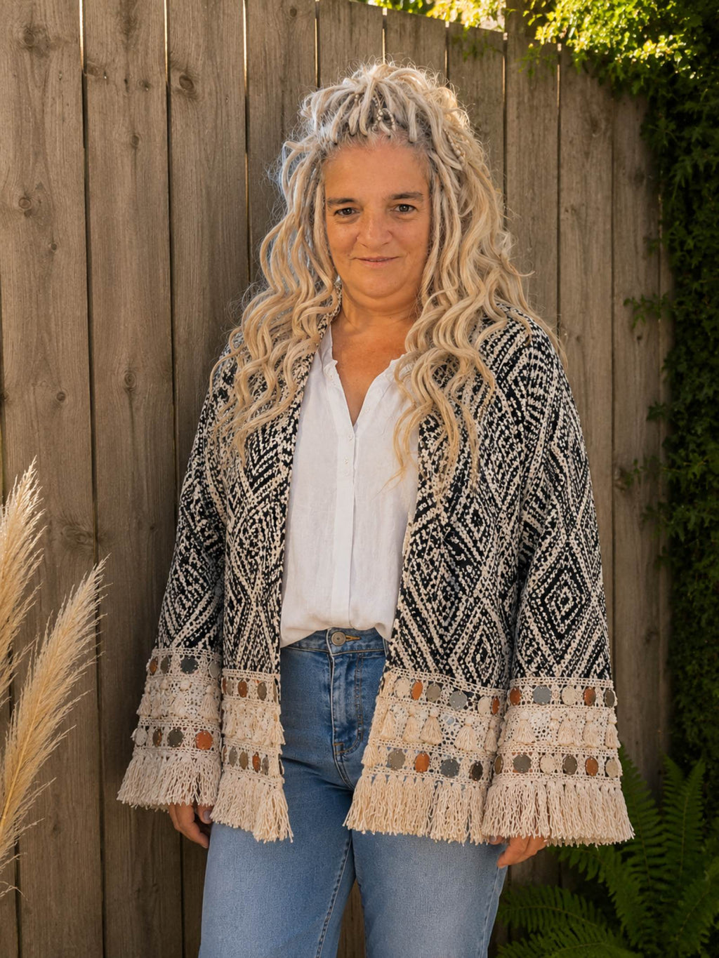 Dames draagt boho kimono jasje zwart crème met franjes.