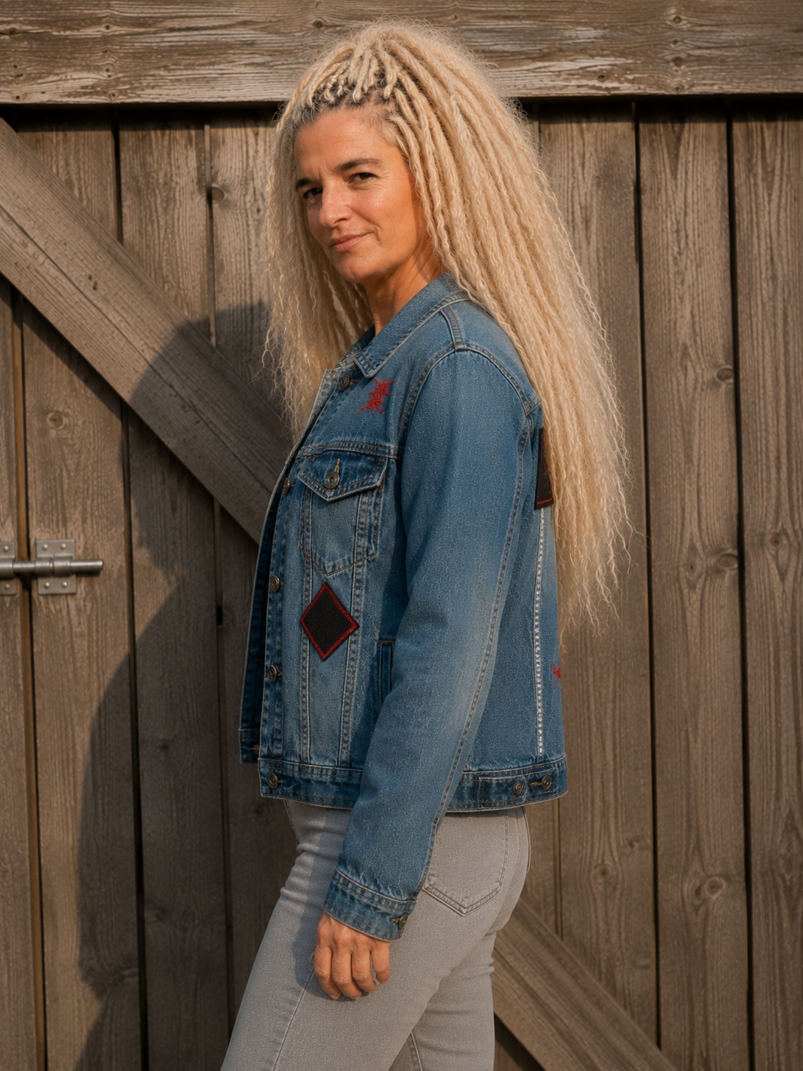 Zijaanzicht van het One of a Kind upcycled denim jasje, gedragen door model.